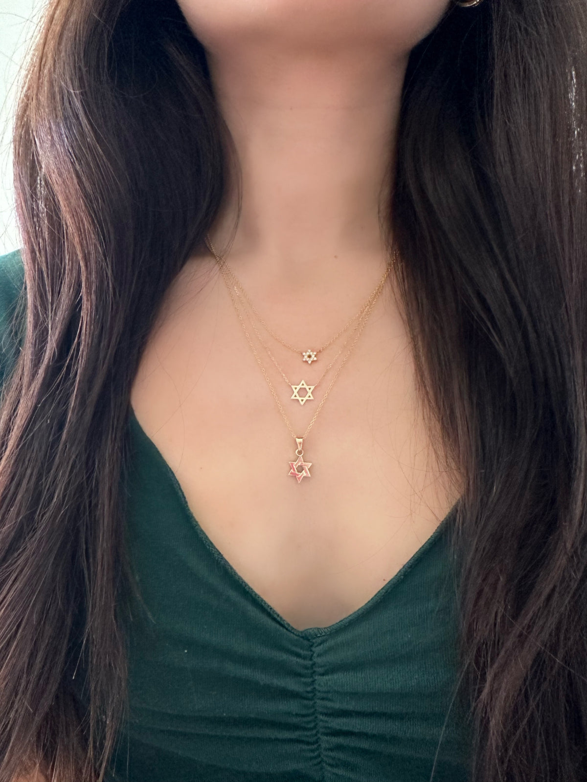close up of three star of david necklaces layered
