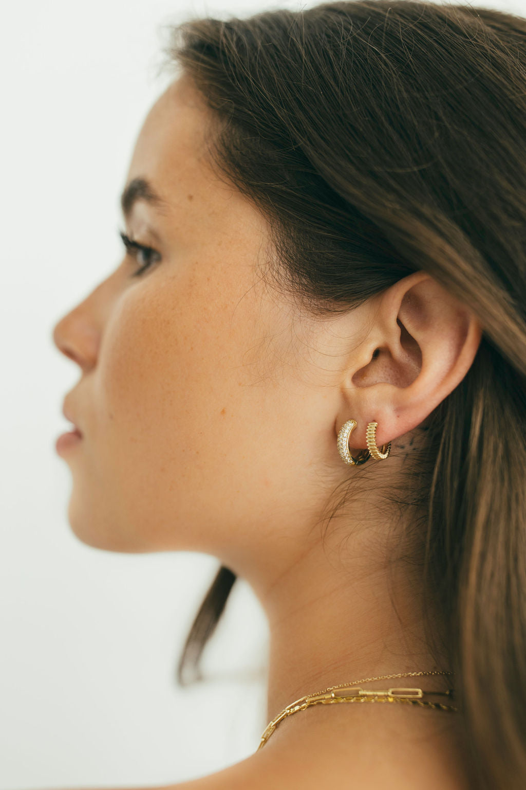 close up of side profile earrings are diamonds and yellow gold