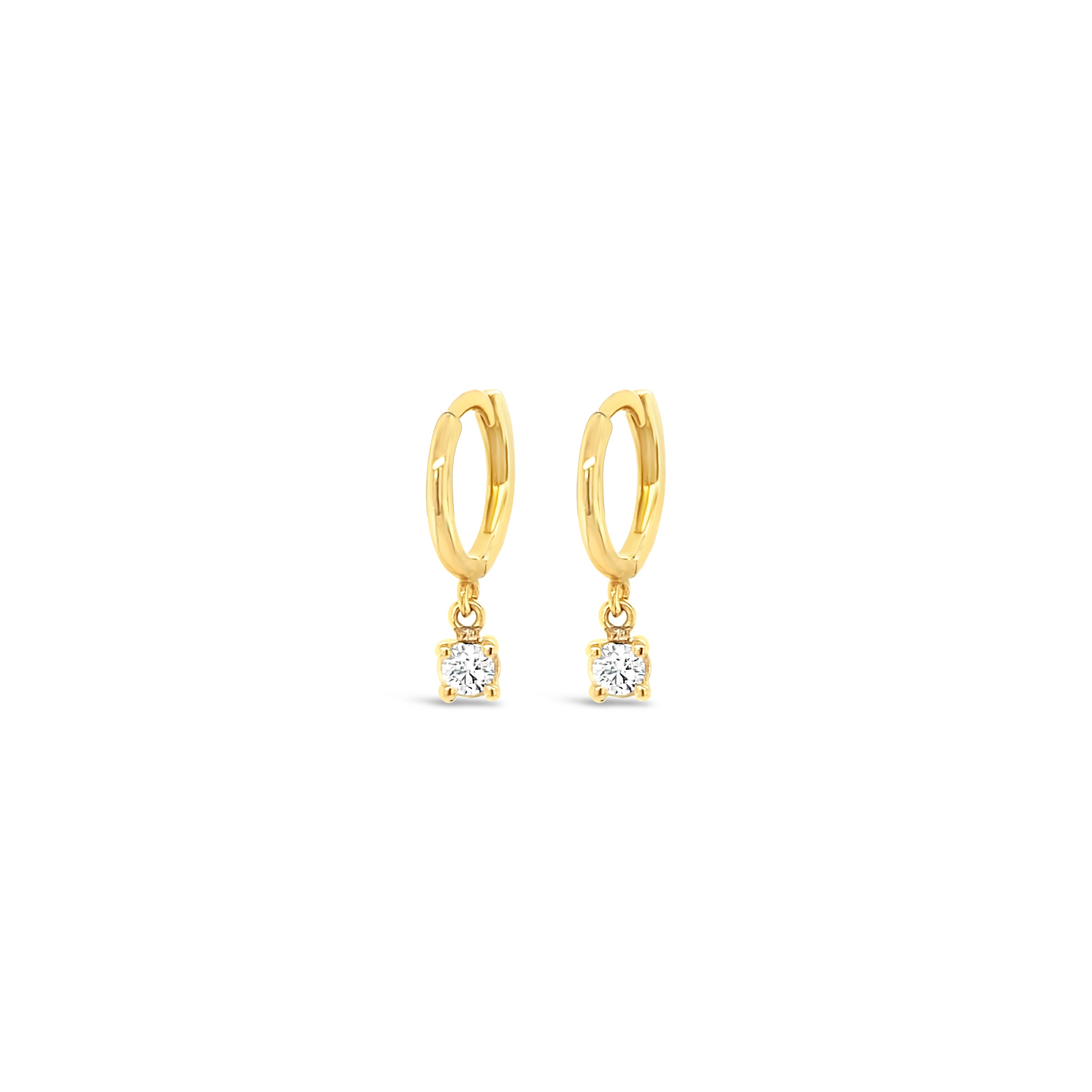 A pair of 14K gold dangling diamond huggie earrings with a prong-set diamond drop.