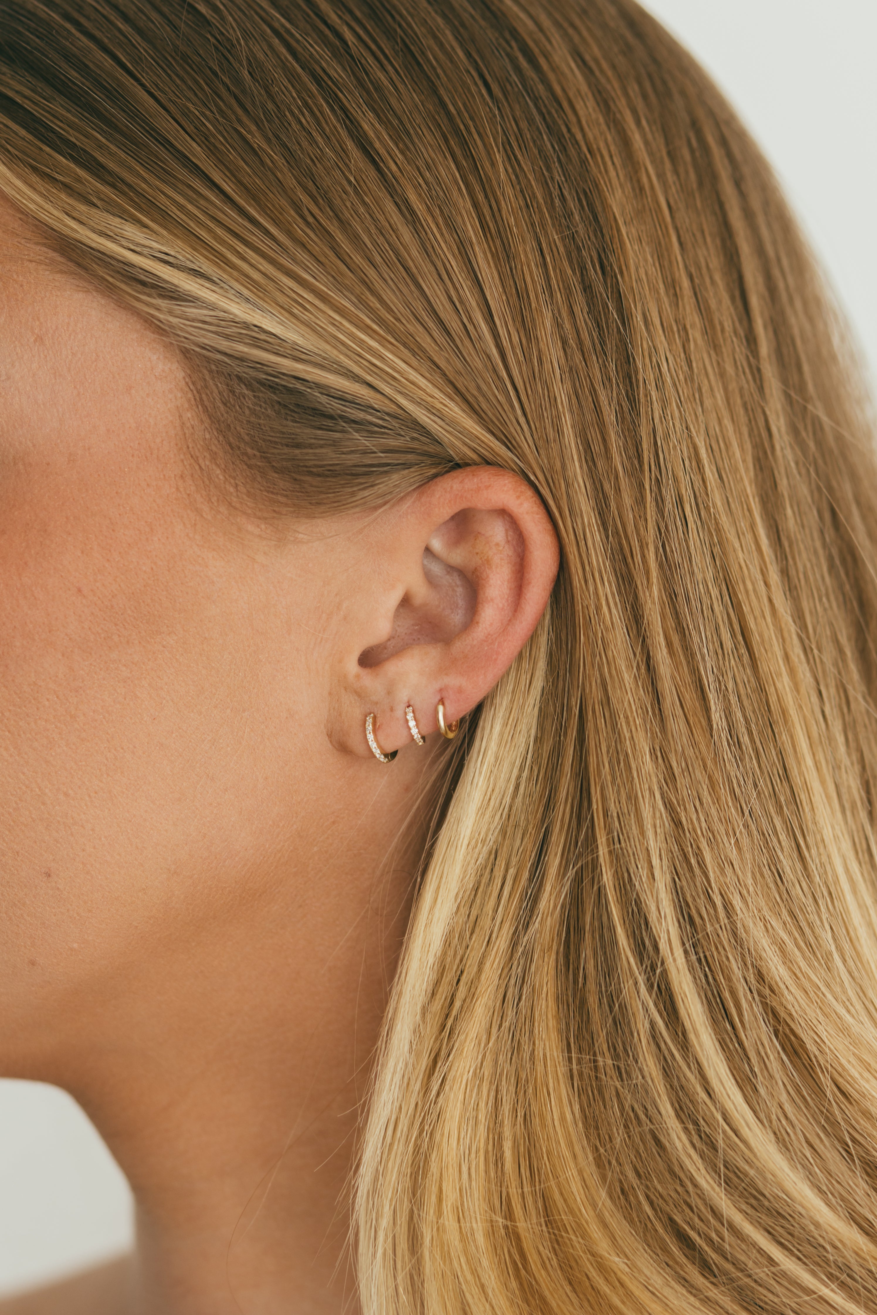 close up of diamond and gold huggie stack