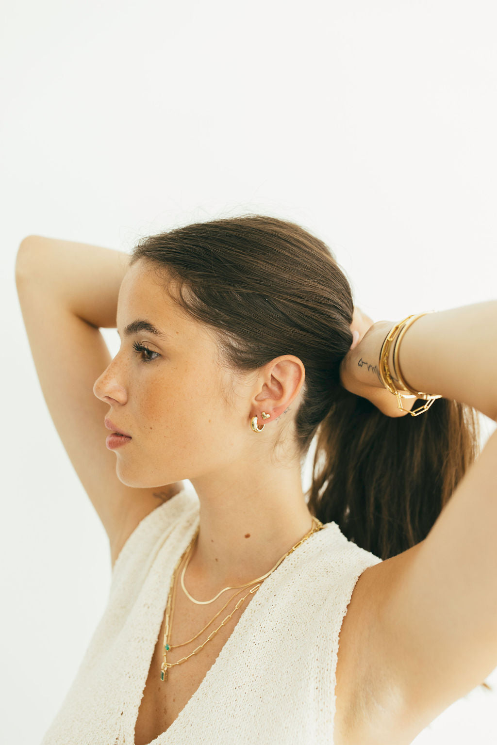 Woman with gold jewelry on a white background