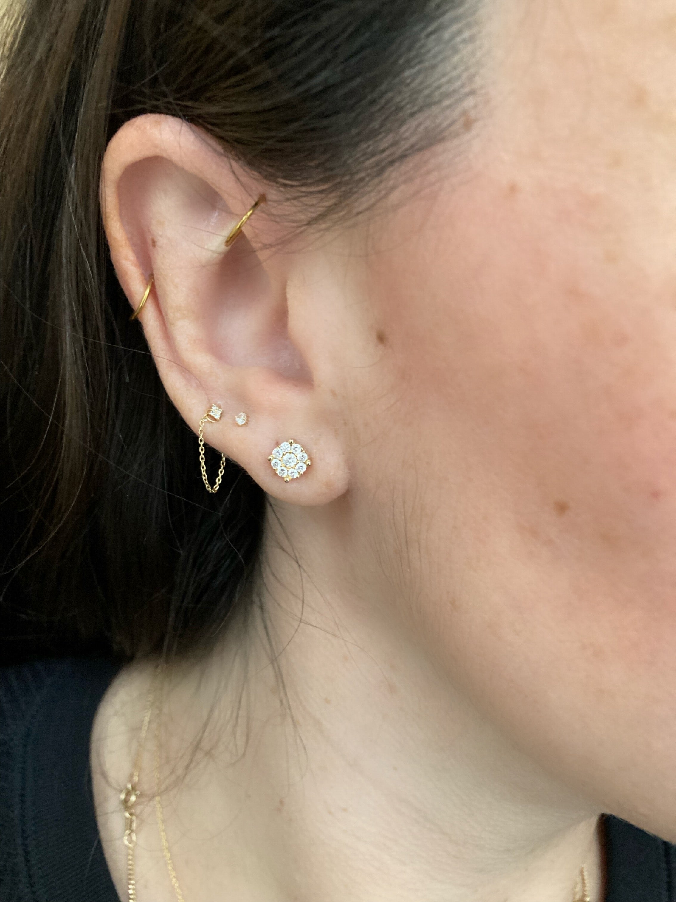 close up of ear wearing yellow gold diamond cluster studs