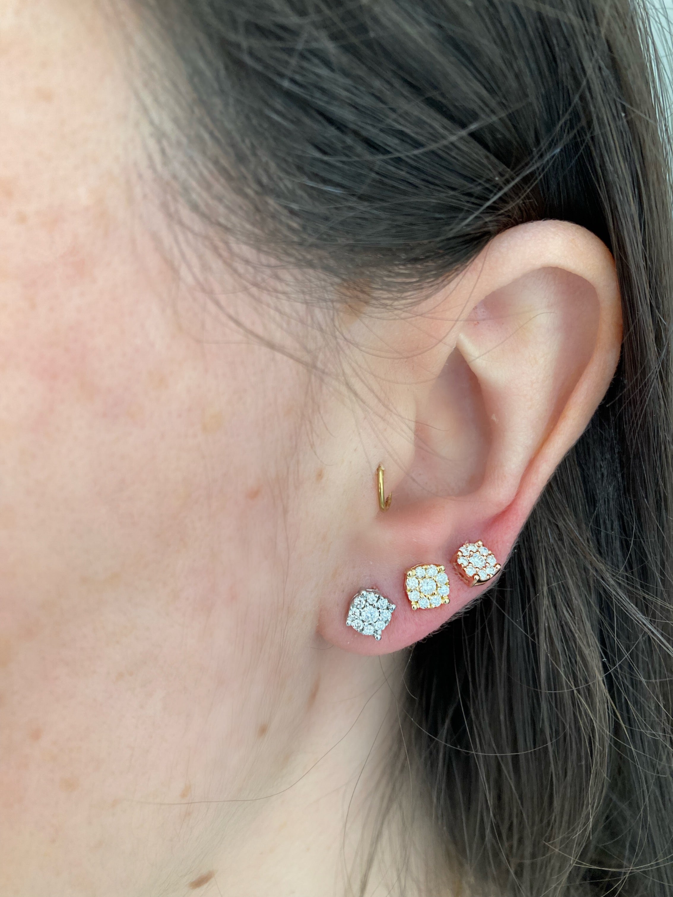 close up of earring stack wearing white gold, yellow gold, and rose gold diamond cluster studs