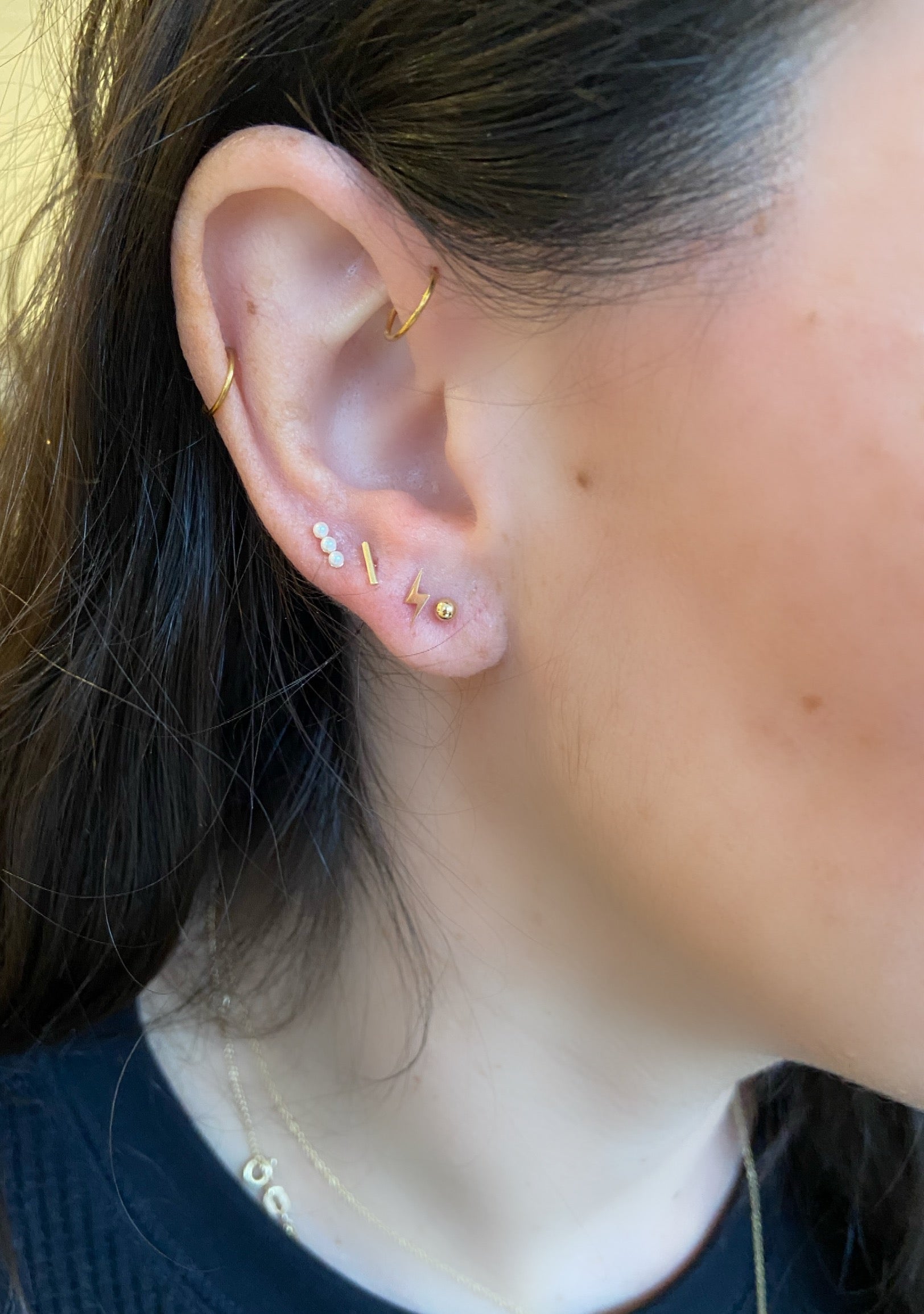 close up of earring stack of bar flat back studs