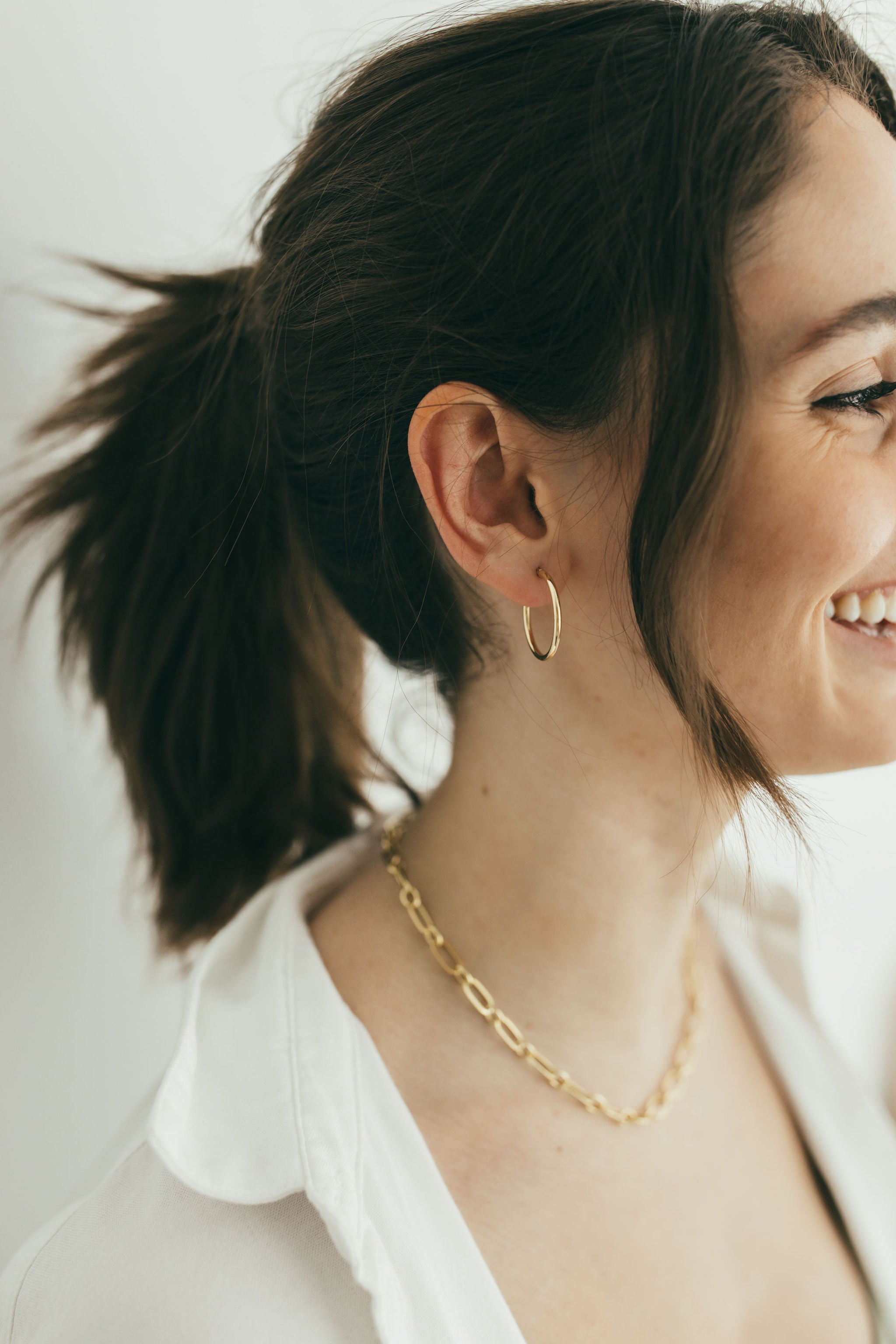 girl smiling wearing medium gold hoops