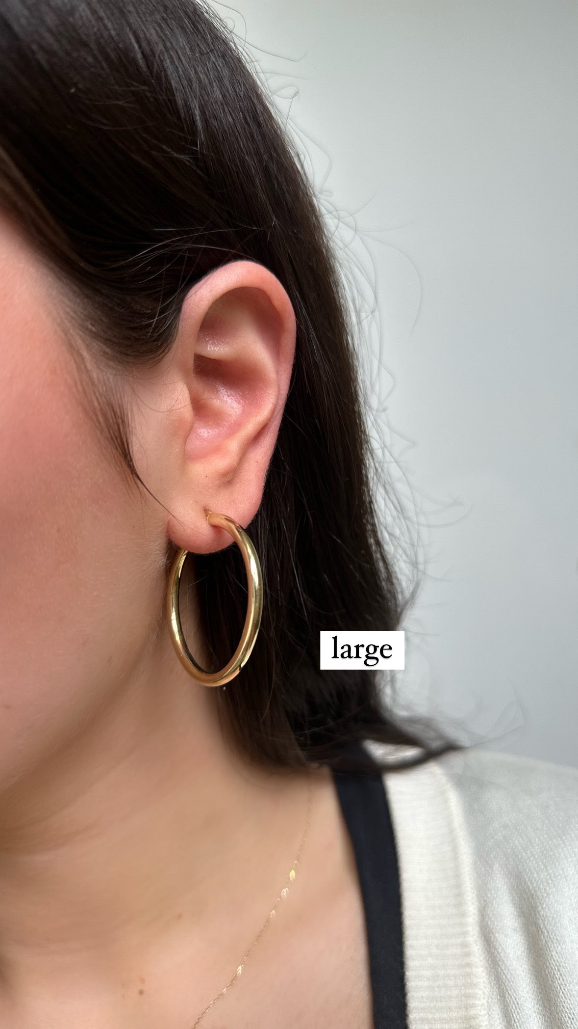 girl wearing gold hoops size large