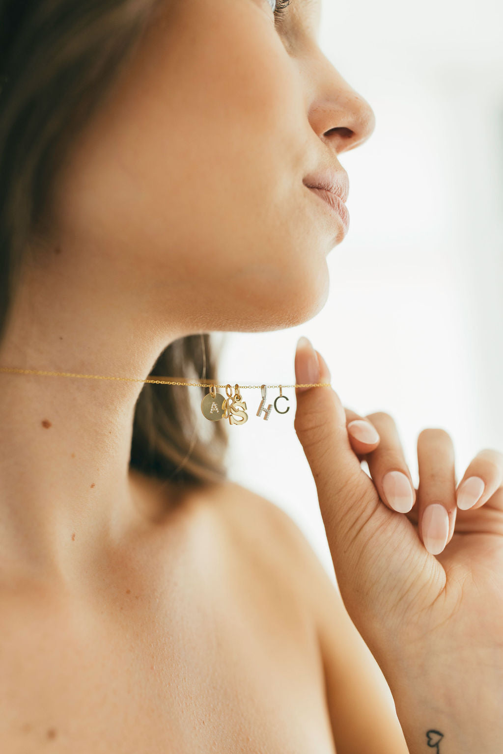 Woman wearing a delicate gold necklace and pendants with a blurred background
