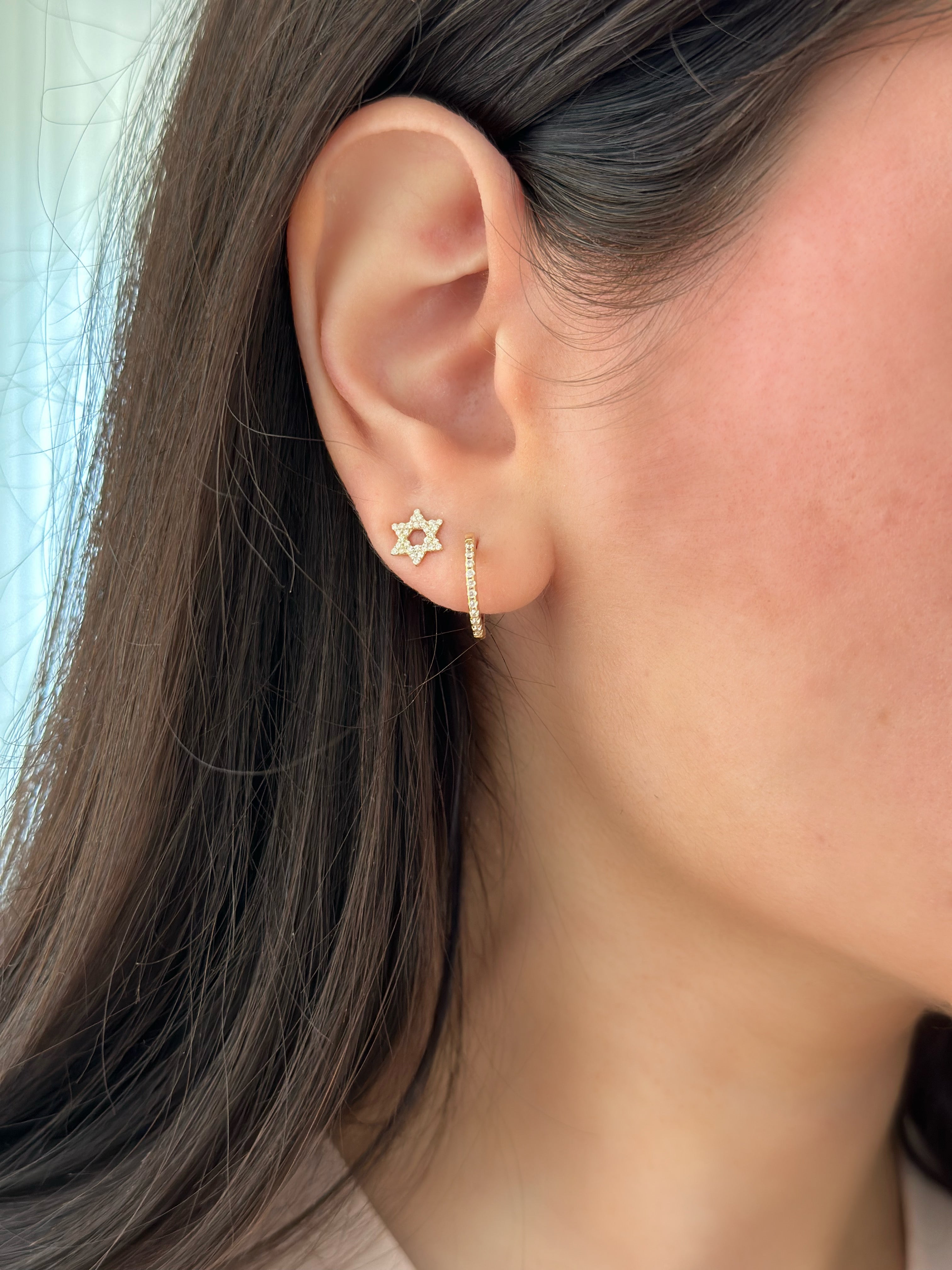 close up of diamond earring stack including diamond star of david studs