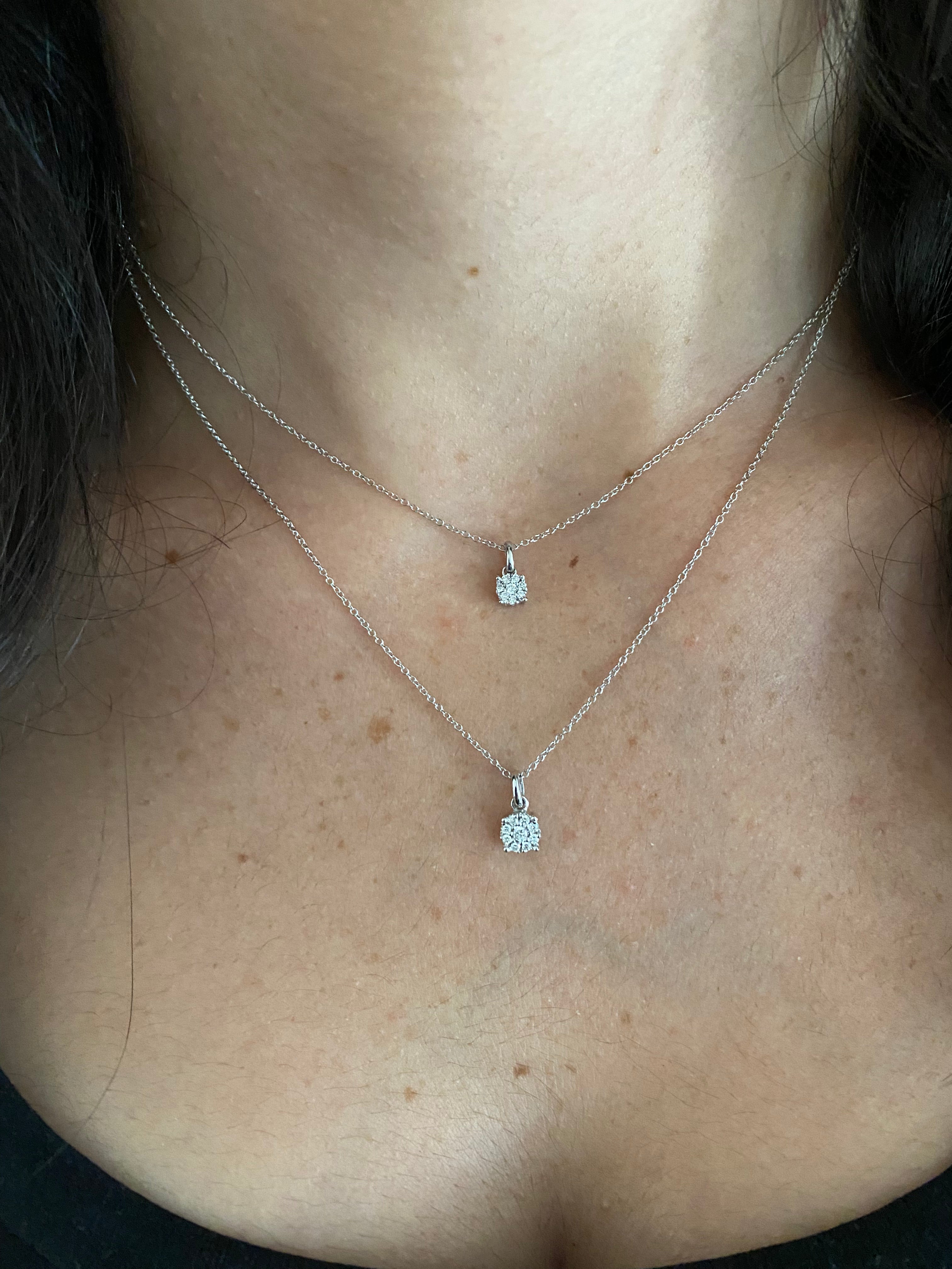 close up of person wearing both sizes small and large of a round diamond illusion pendant