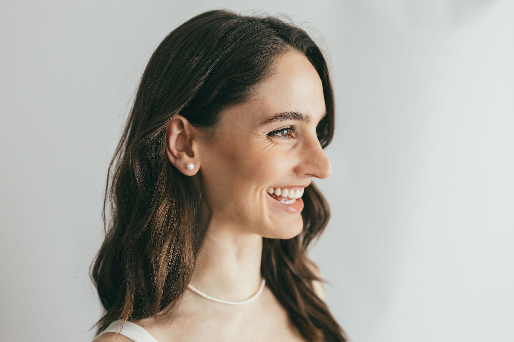 close up of smiling girl wearing pearl studs