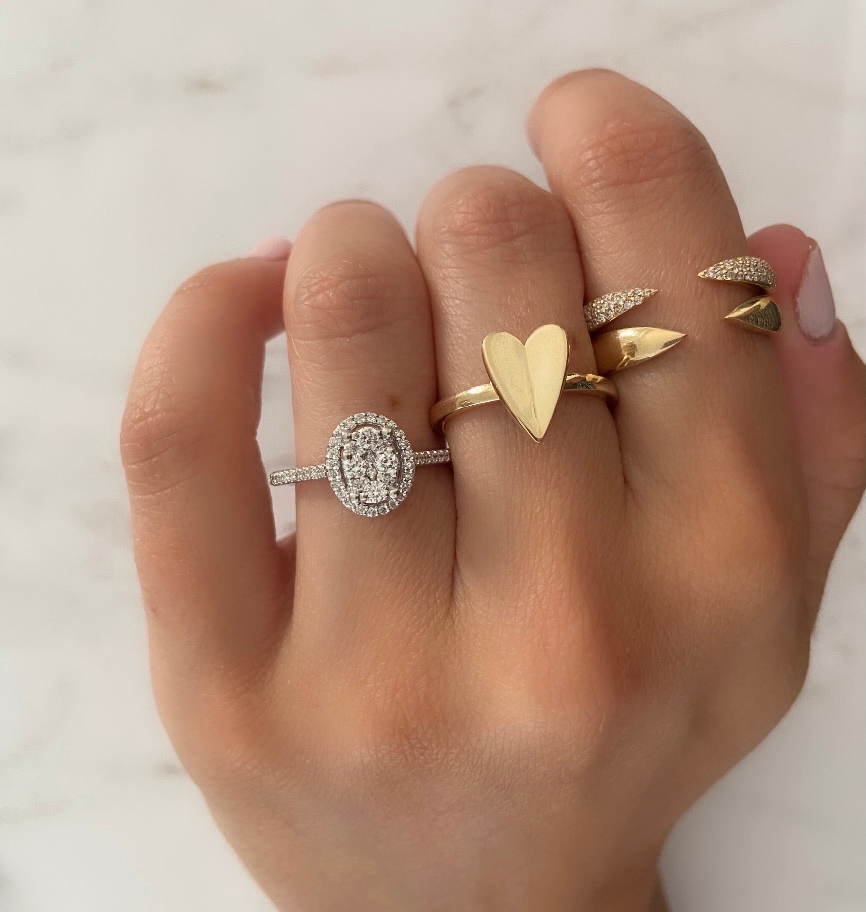 Gold rings styled on a person's hand with a white background