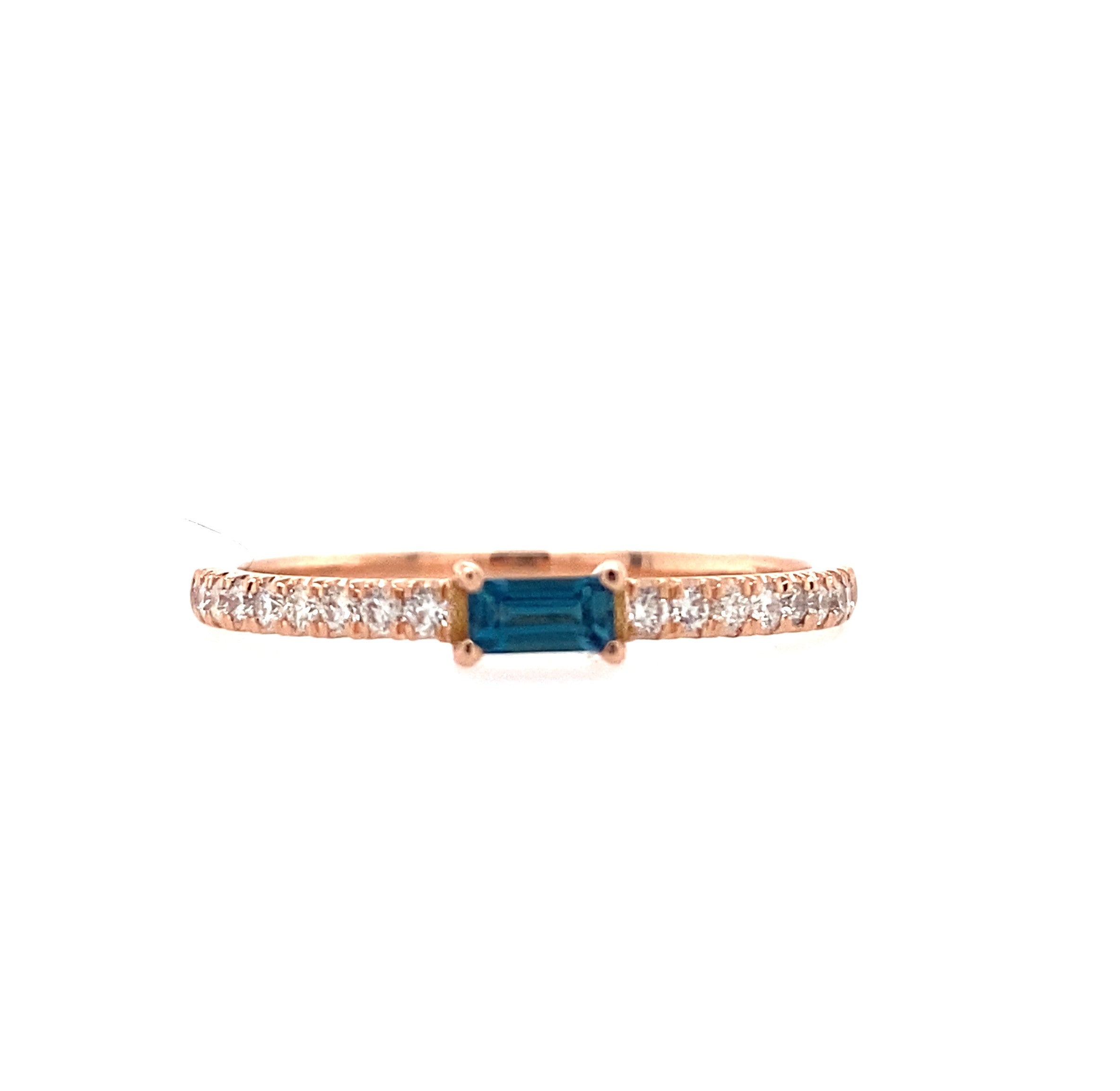 A rose gold ring with a baguette birthstone in the center, surrounded by smaller diamonds along the band.