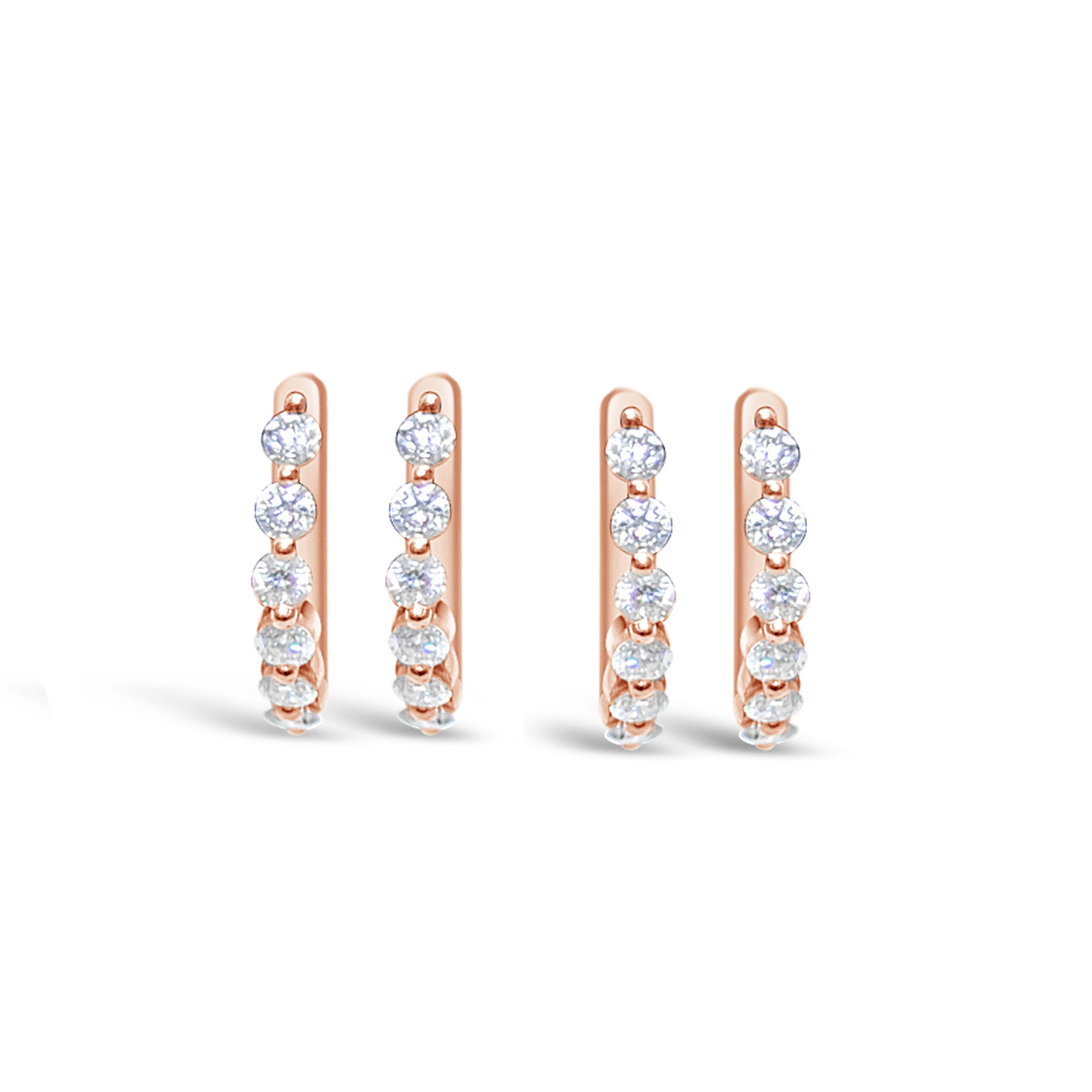 A pair of diamond huggie earrings with a butterfly closure, featuring multiple diamonds set in a single prong design in rose gold.