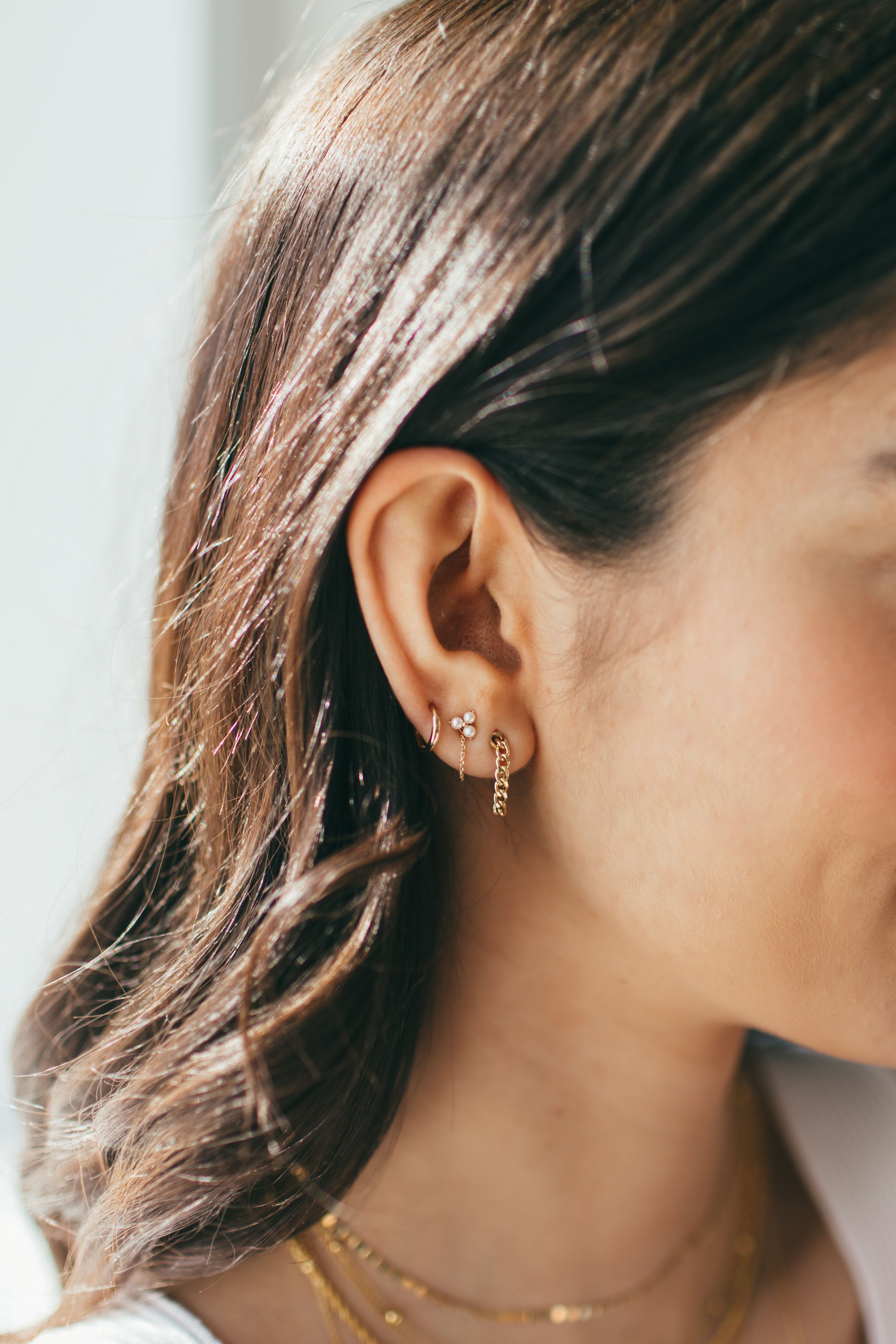 close up of gold and pearl earring stack