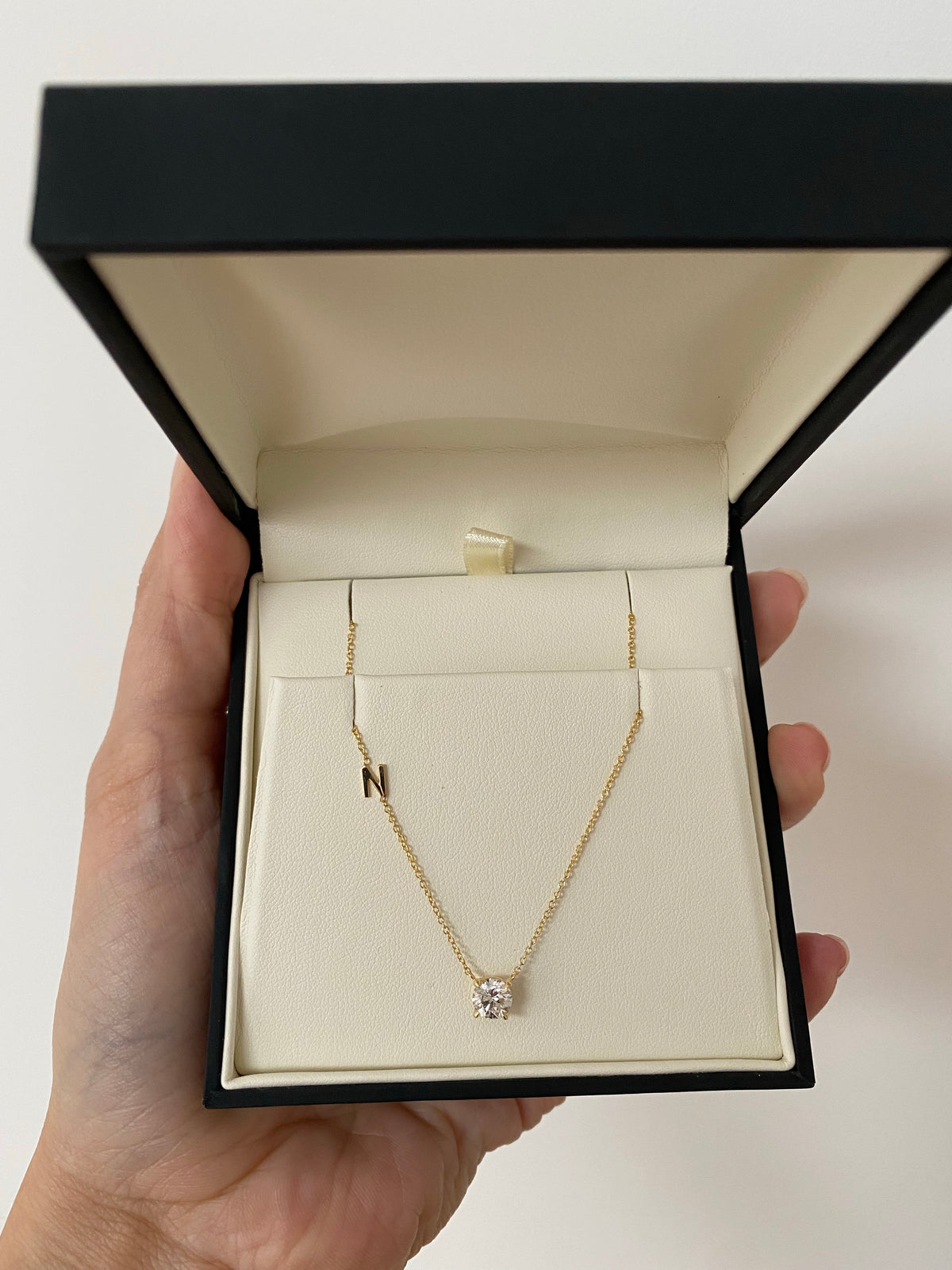 a floating diamond necklace customized with an initial on the side