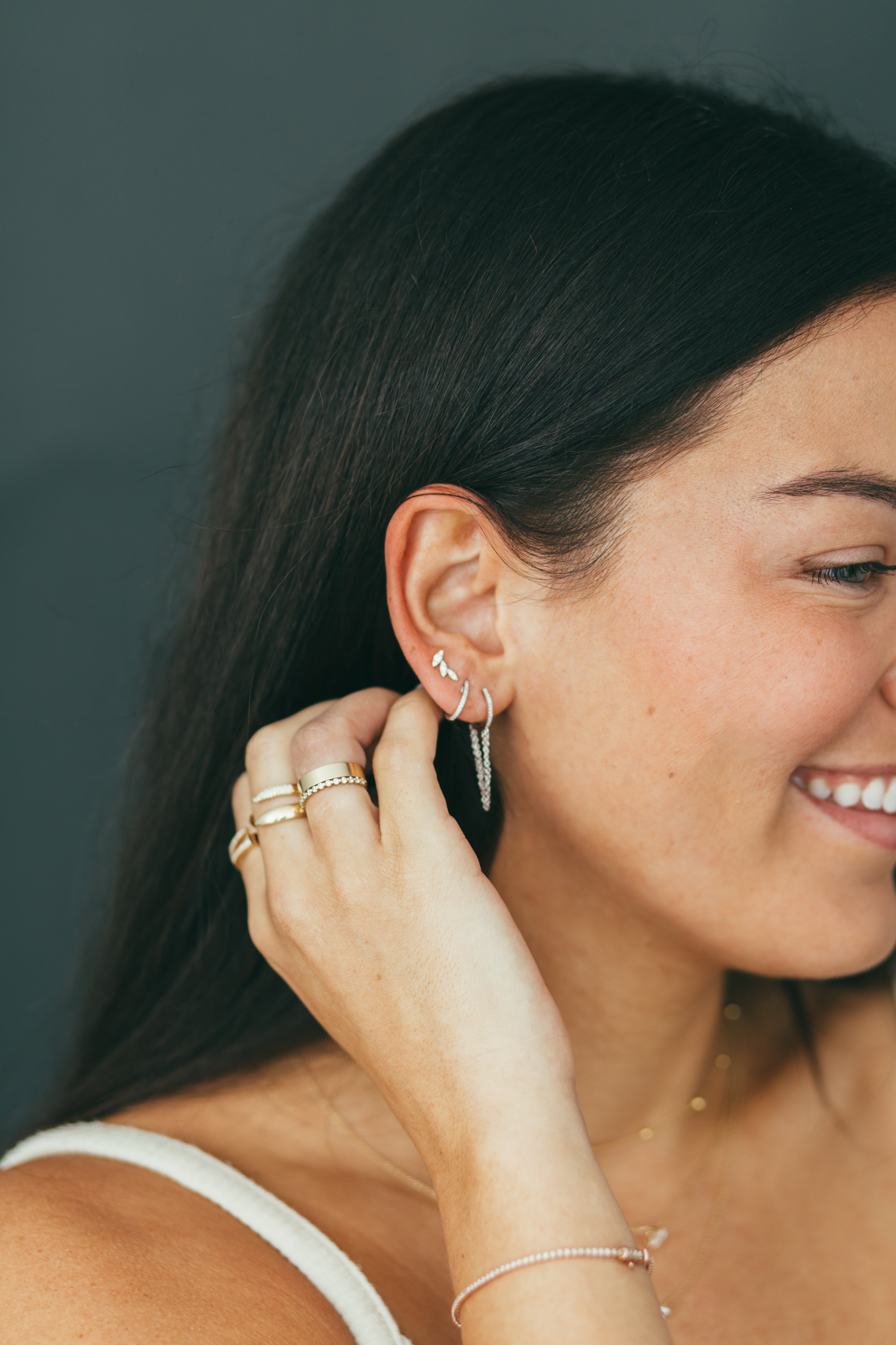 girl wearing gold rings and diamond huggies