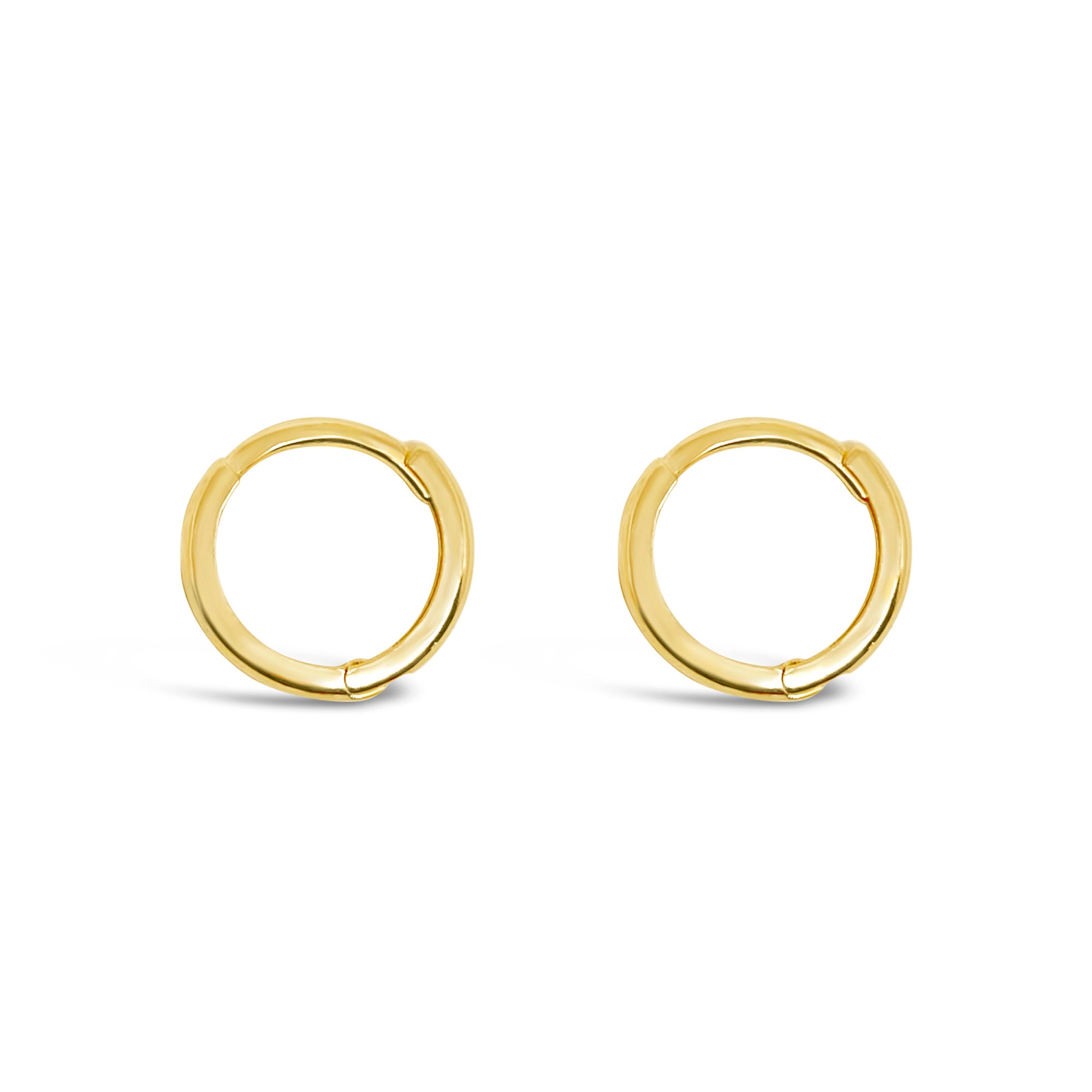 A pair of 14K gold mini huggie earrings on a white background