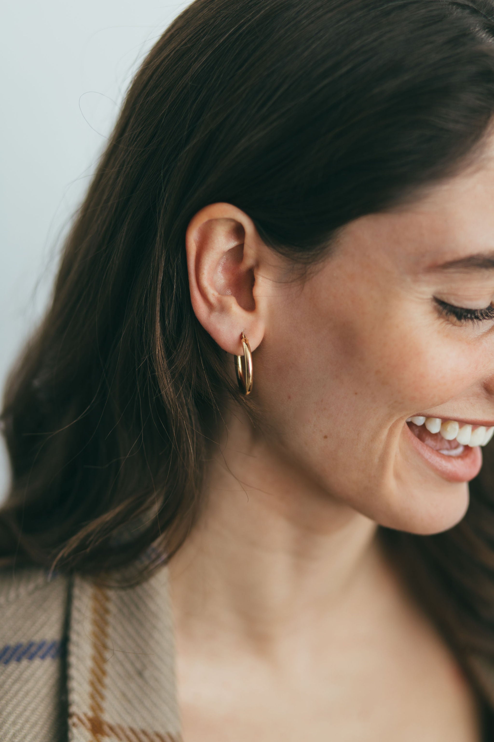 a girl smiling with gold hoops in her ear