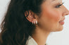 Detailed view of diamond huggies on ear, emphasizing their elegant design and luxurious appeal.