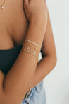 Close-up on wrist showing Bold Initial and Diamond Bracelet alongside a stack of delicate gold bracelets, illustrating versatile styling options.