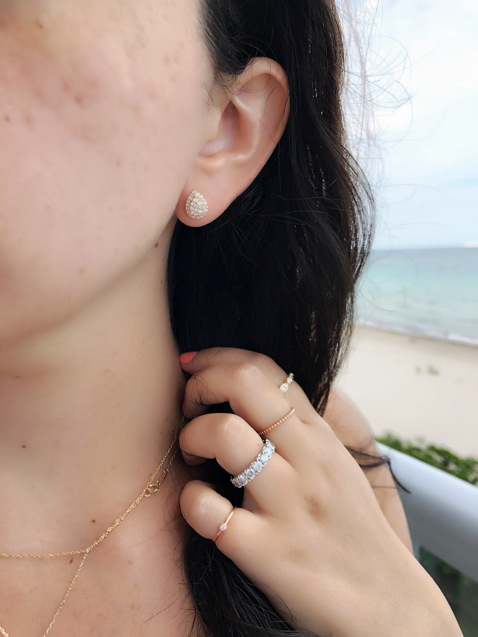 close up of ear wearing rose gold pear shaped diamond studs