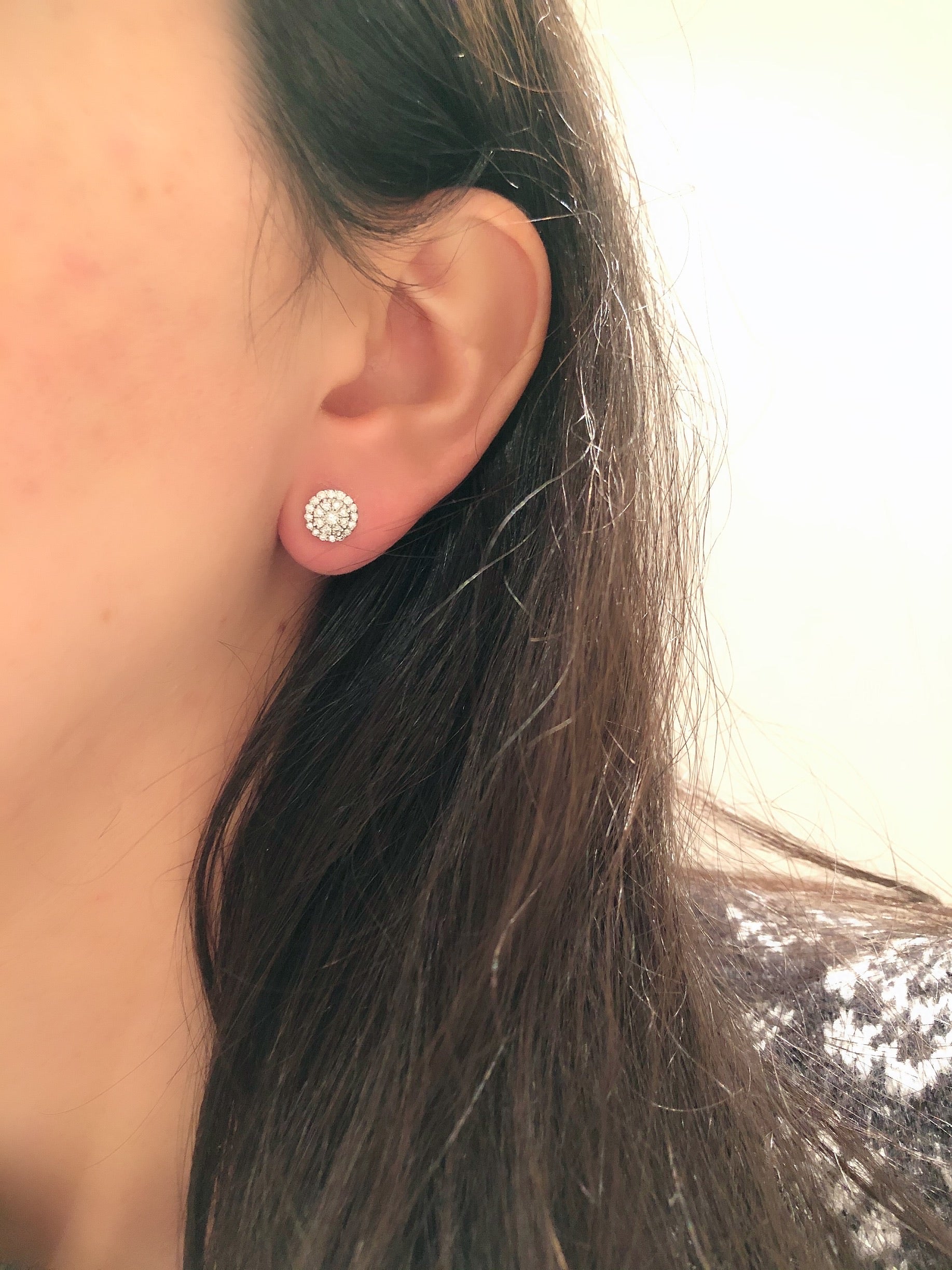 close up of ear wearing round illusion diamond studs