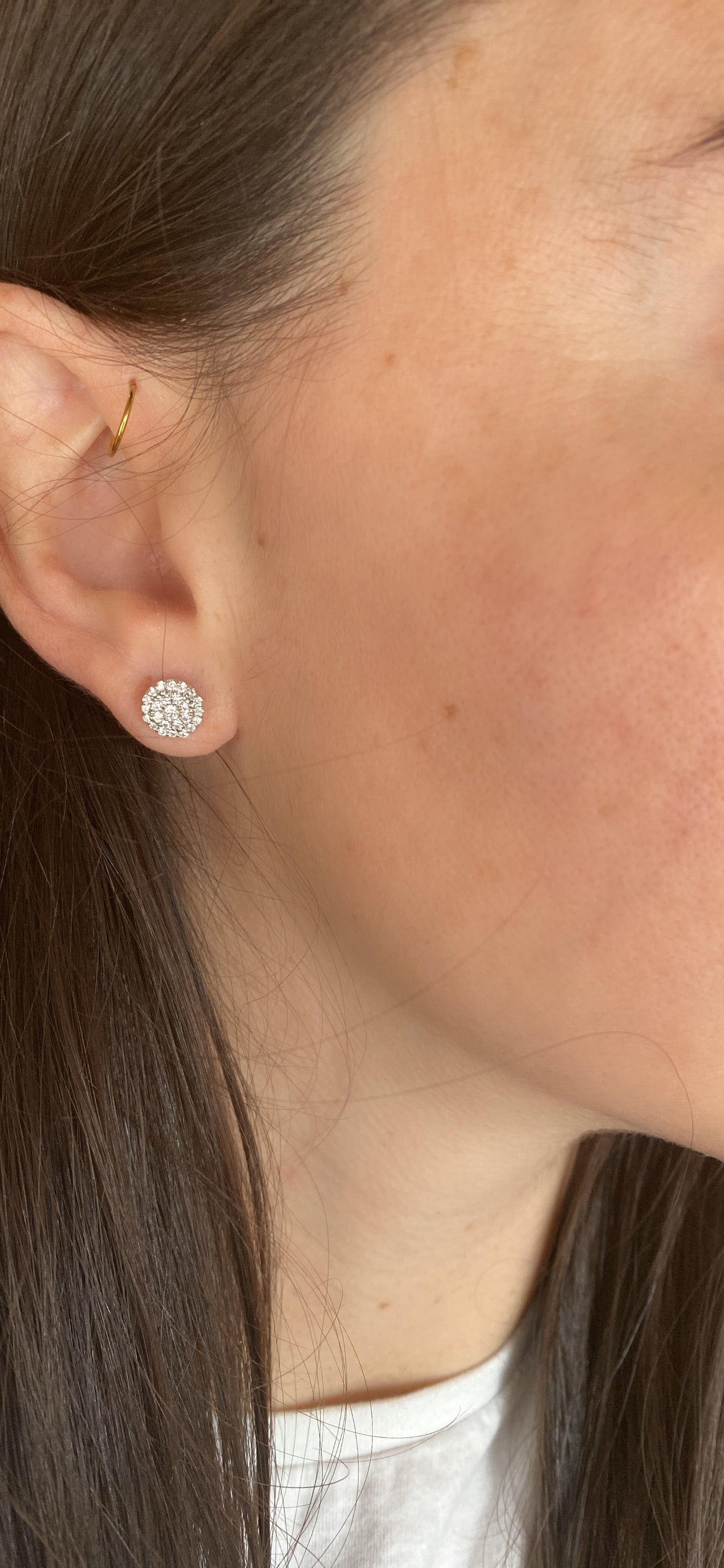 close up of ear wearing large diamond illusion studs