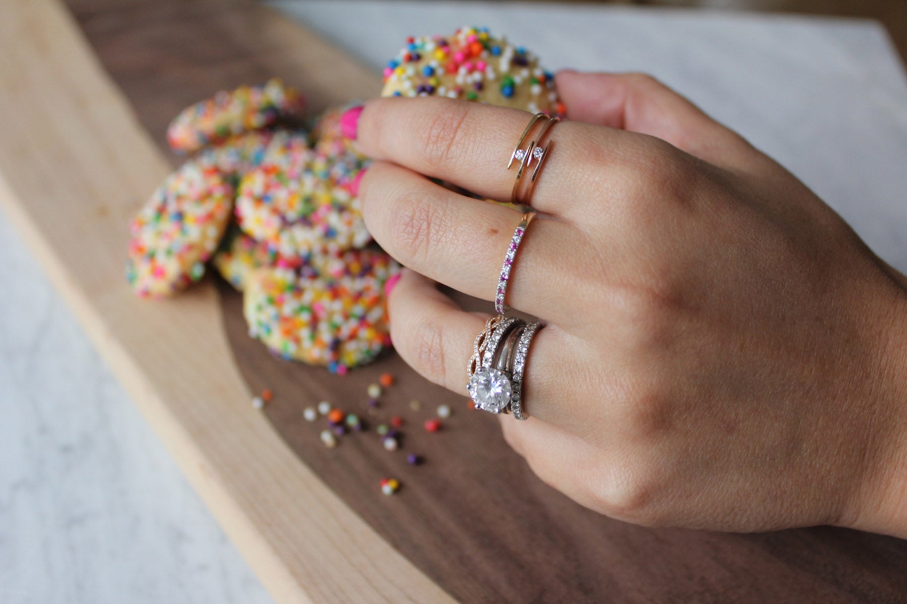 Hand adorned with colorful gemstone rings from Jessica Jewellery, symbolizing personality and playful elegance.