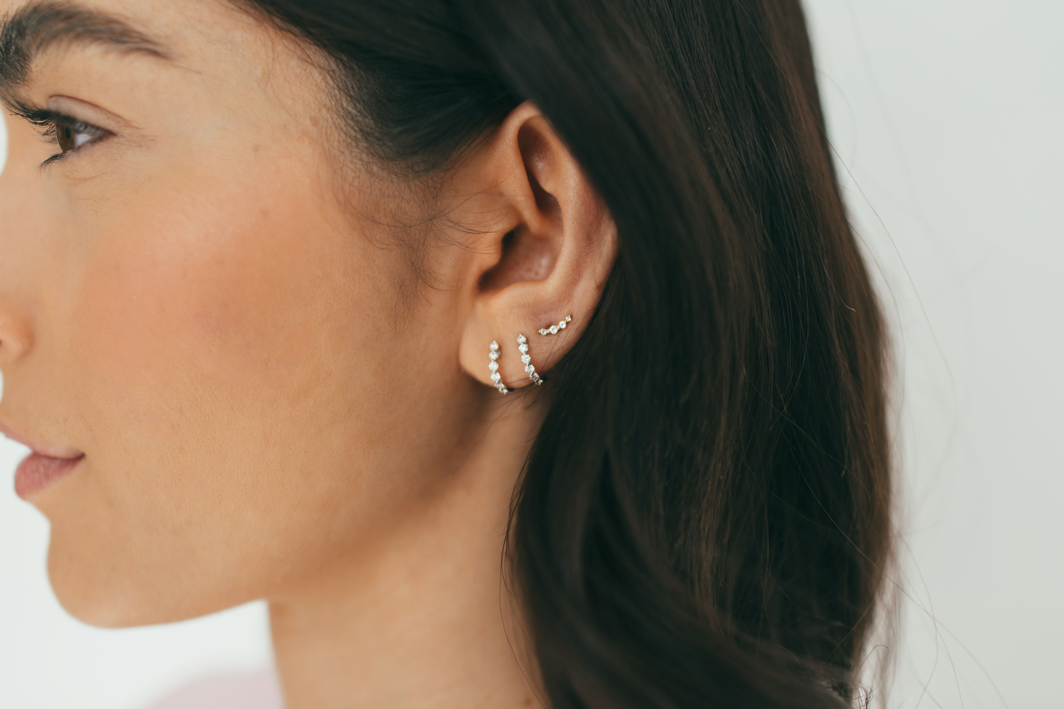 woman wearing multiple diamond earrings