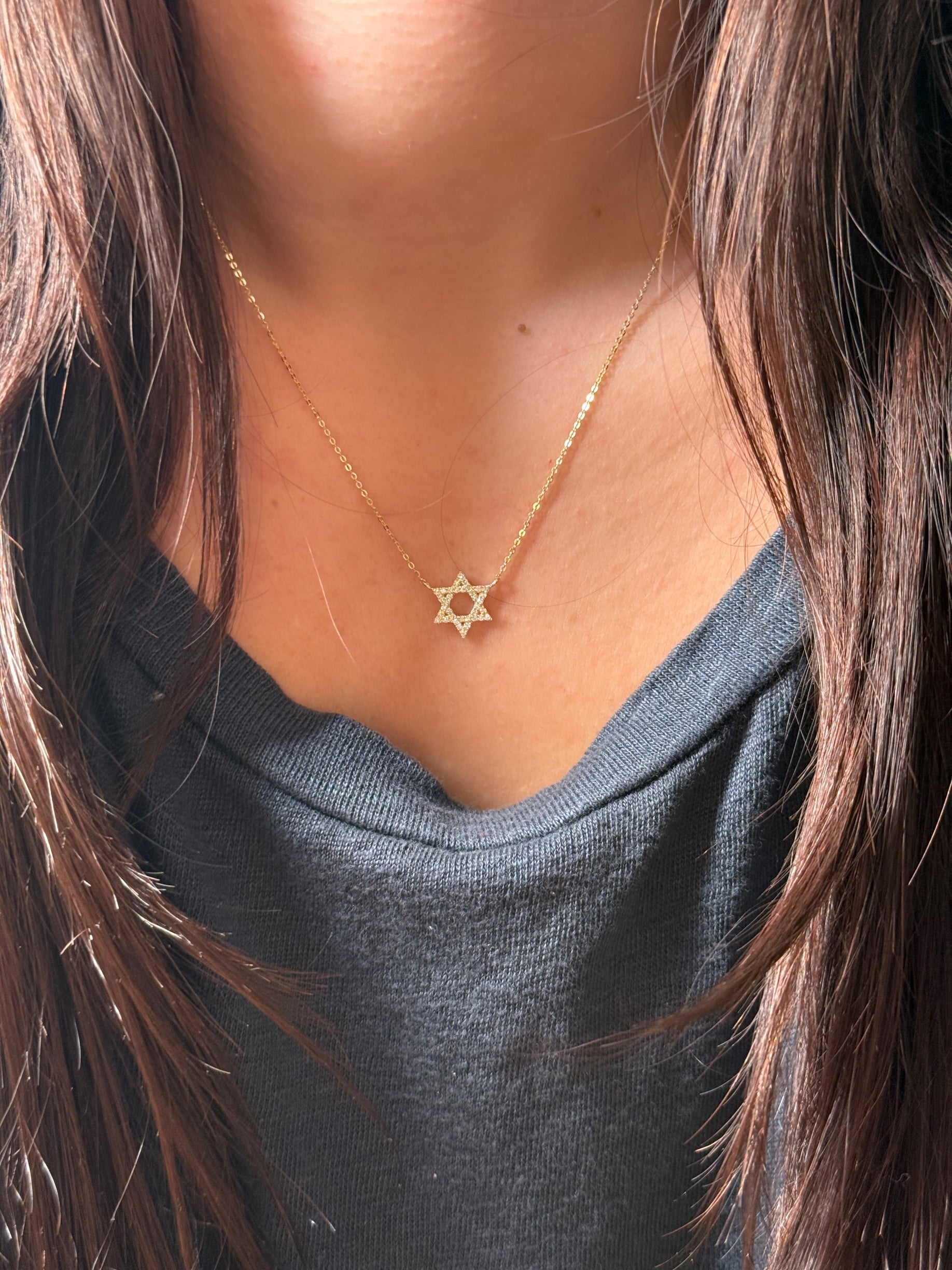 Gold and diamond Star of David Necklace worn by a model.
