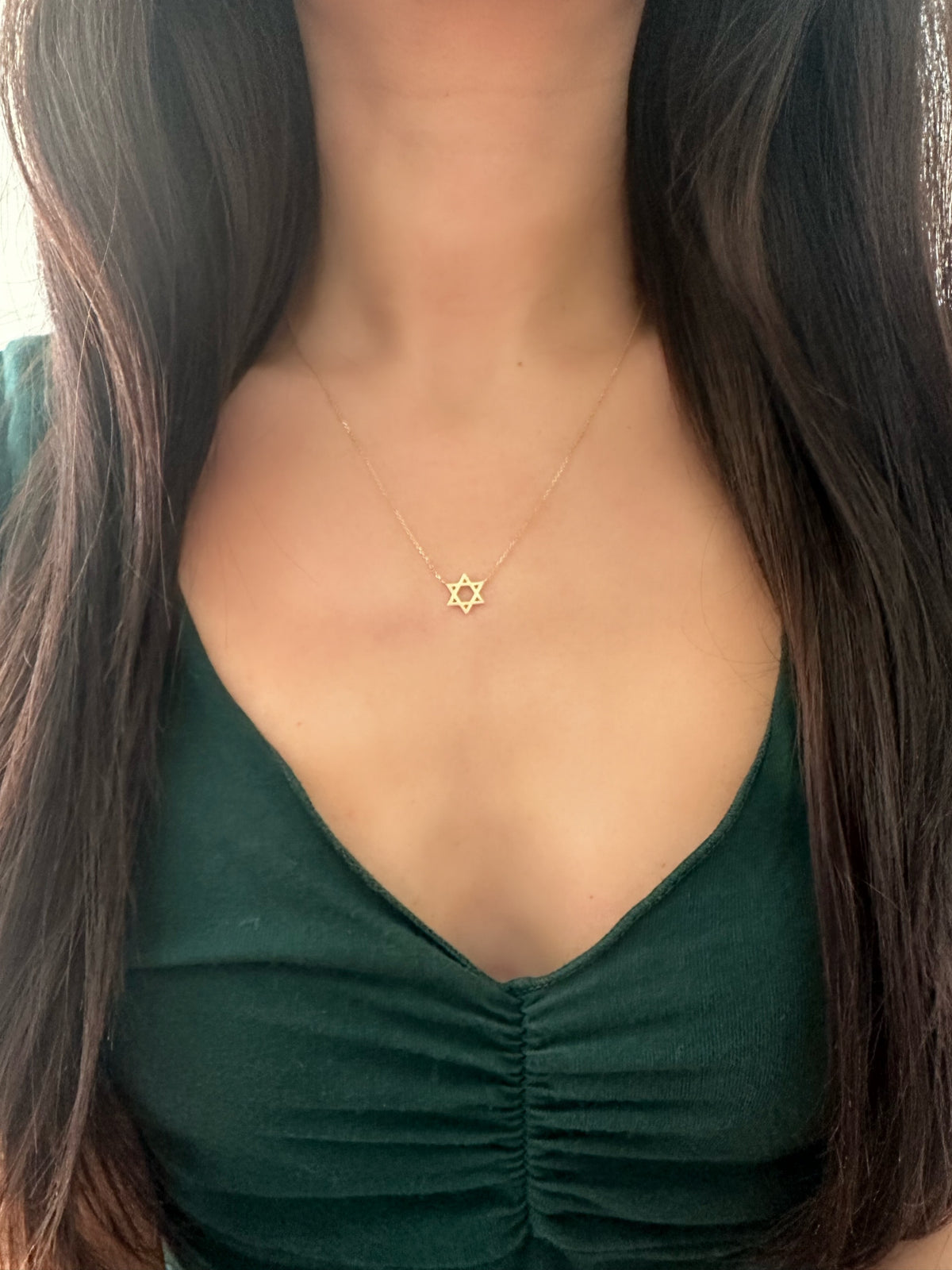 woman wearing a star of david necklace