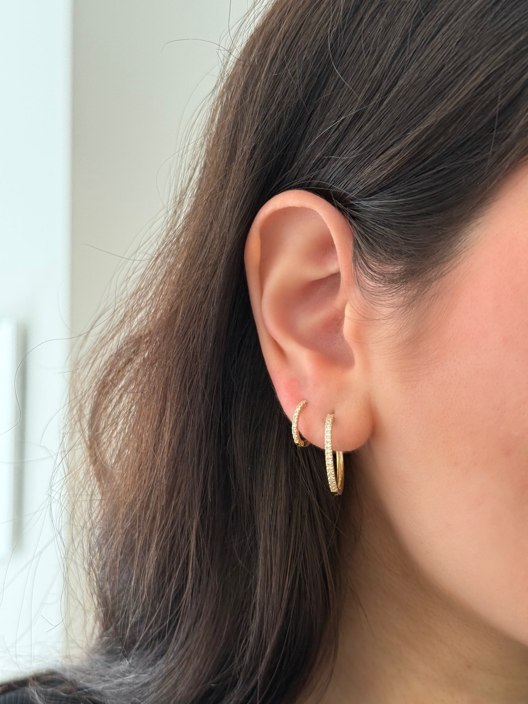 close up of ear wearing a stack of lab grown diamond hoops