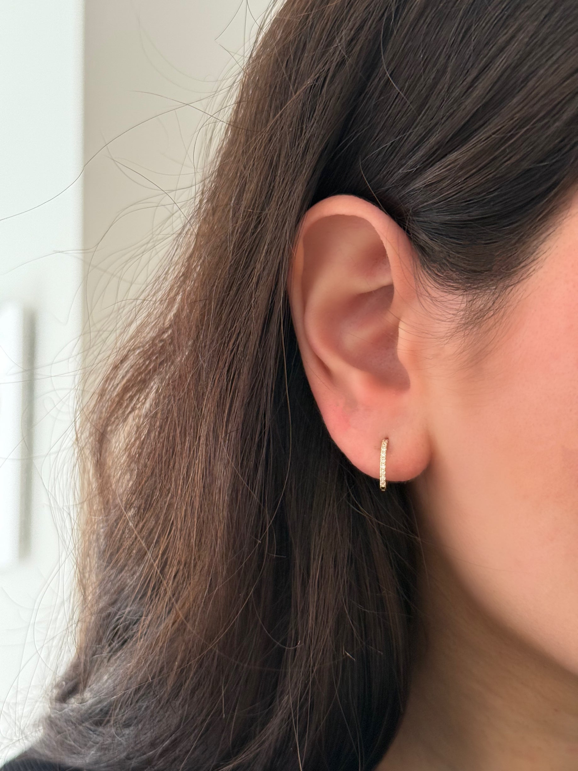 close up of ear wearing lab grown diamond huggie