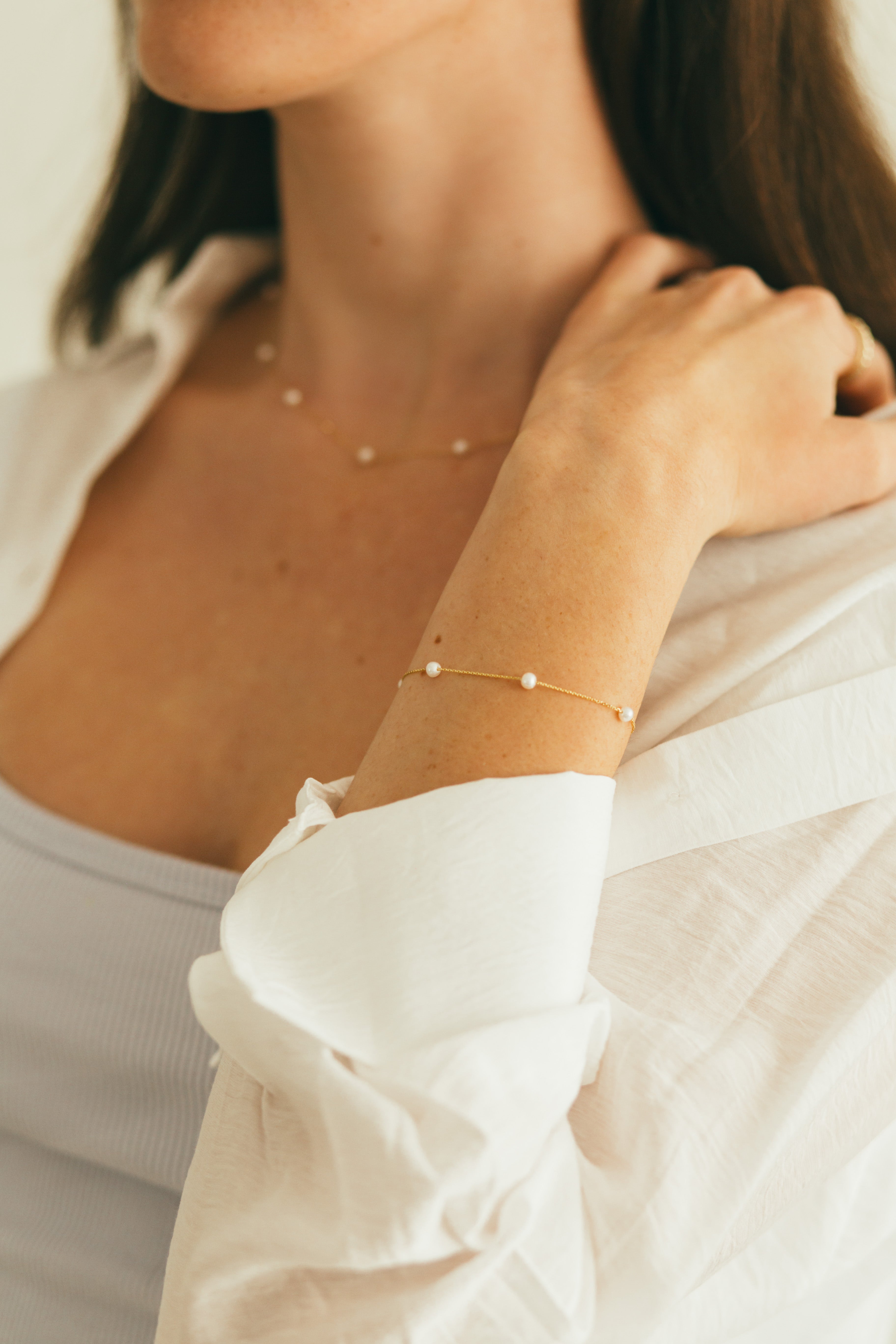 close up of girls wrist wearing a pearl bracelet