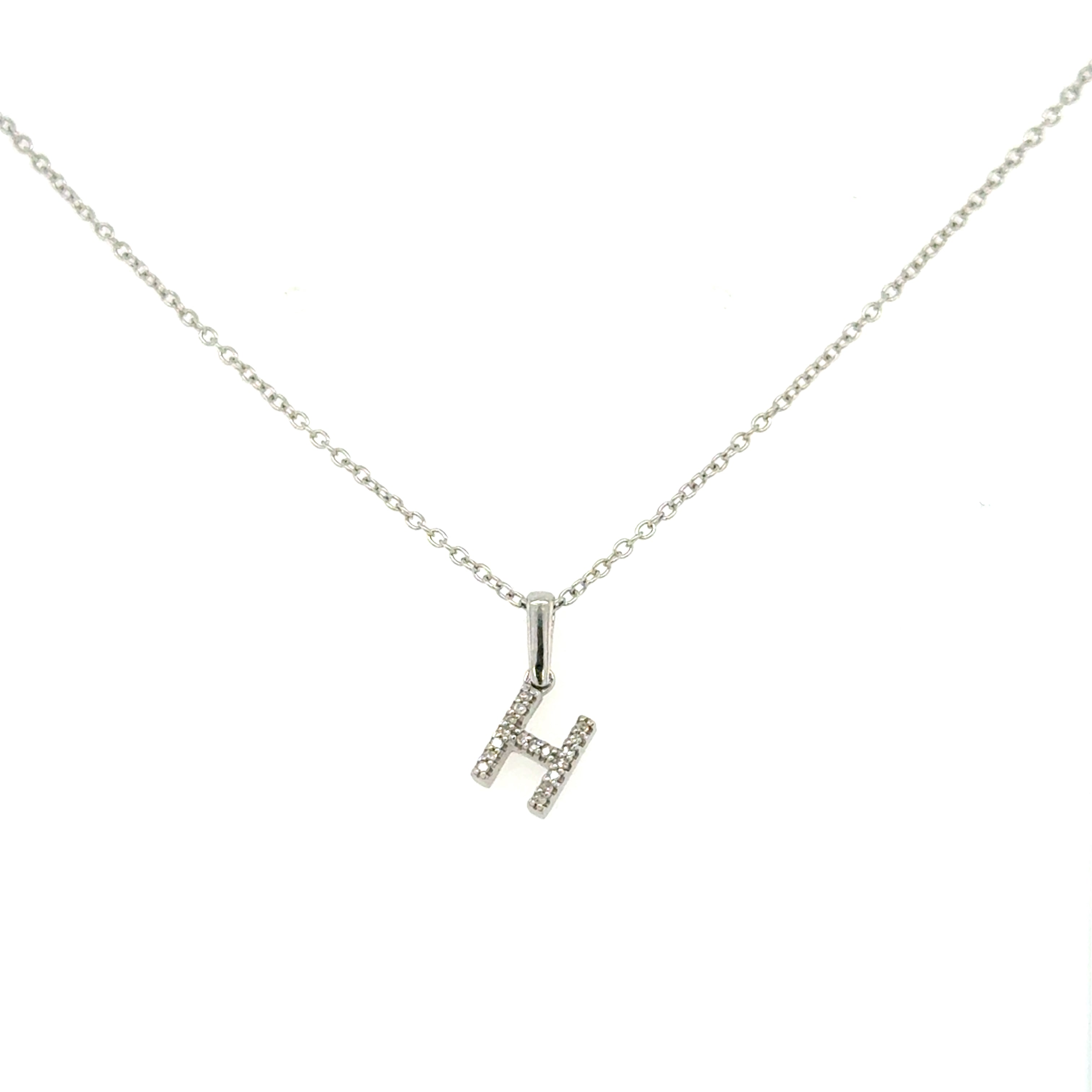 A 10K gold diamond initial charm necklace with a cable chain, featuring a gold 'H' initial encrusted with diamonds.