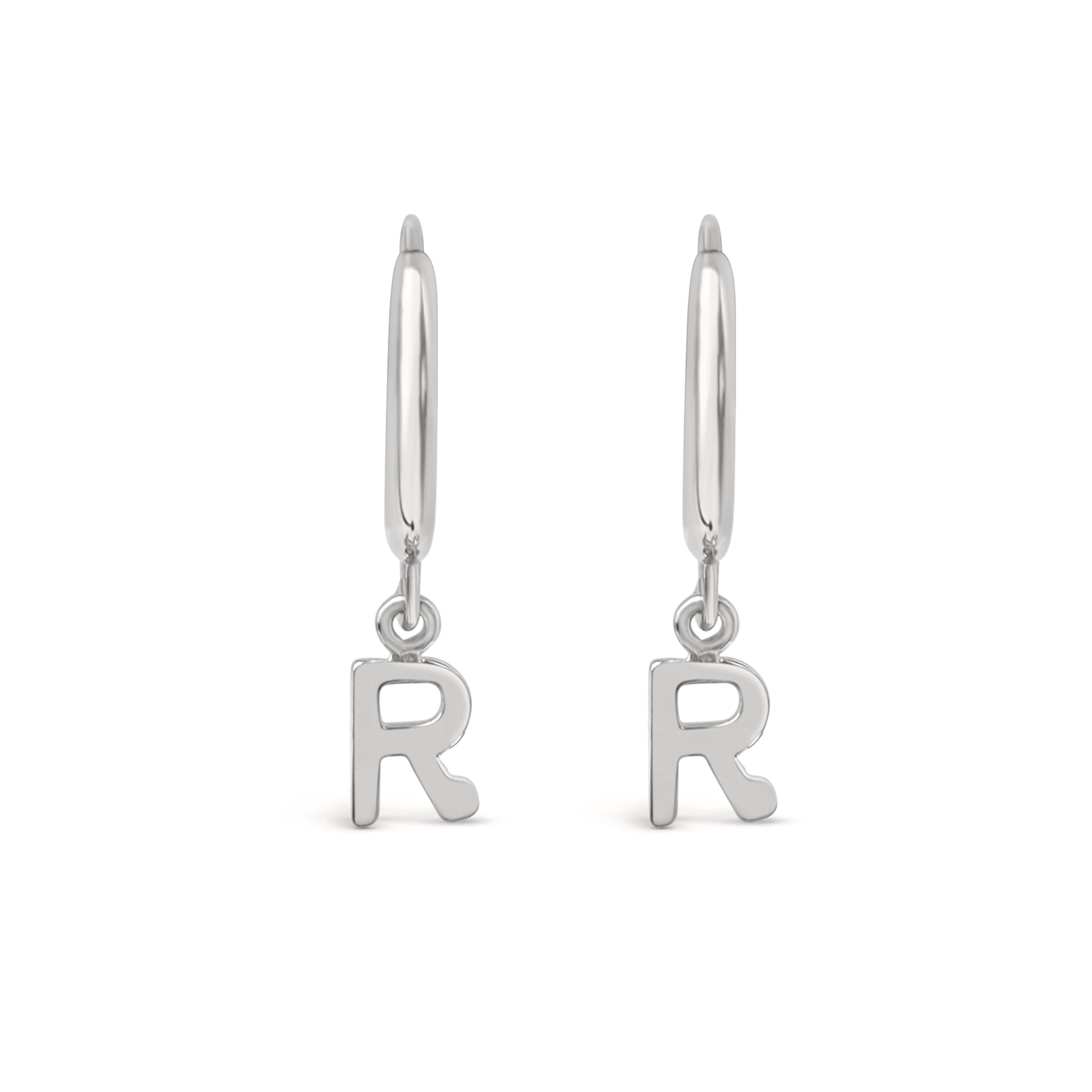 Silver earrings with 'R' charms on a white background