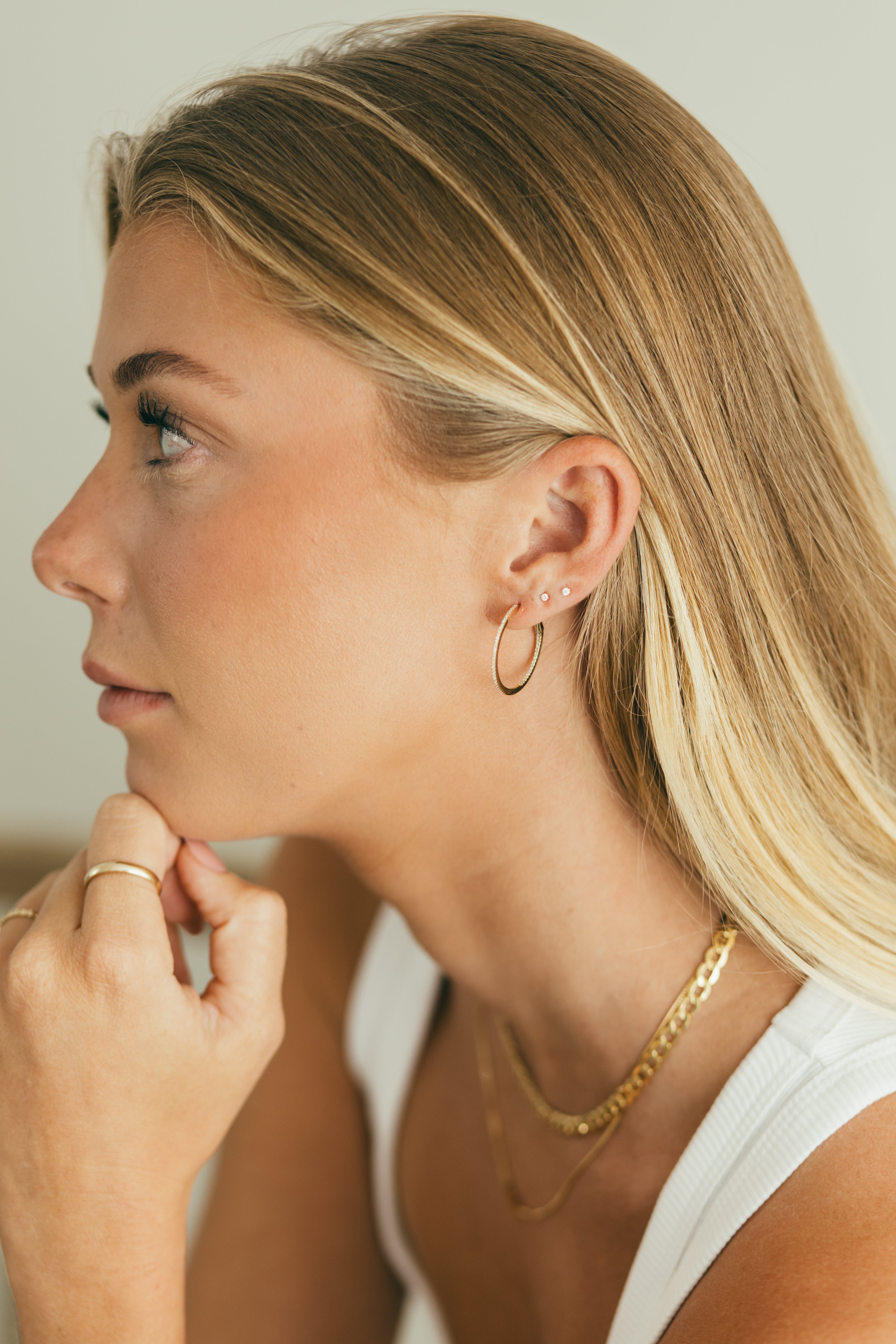 side profile of girl wearing diamond hoops and diamond studs 