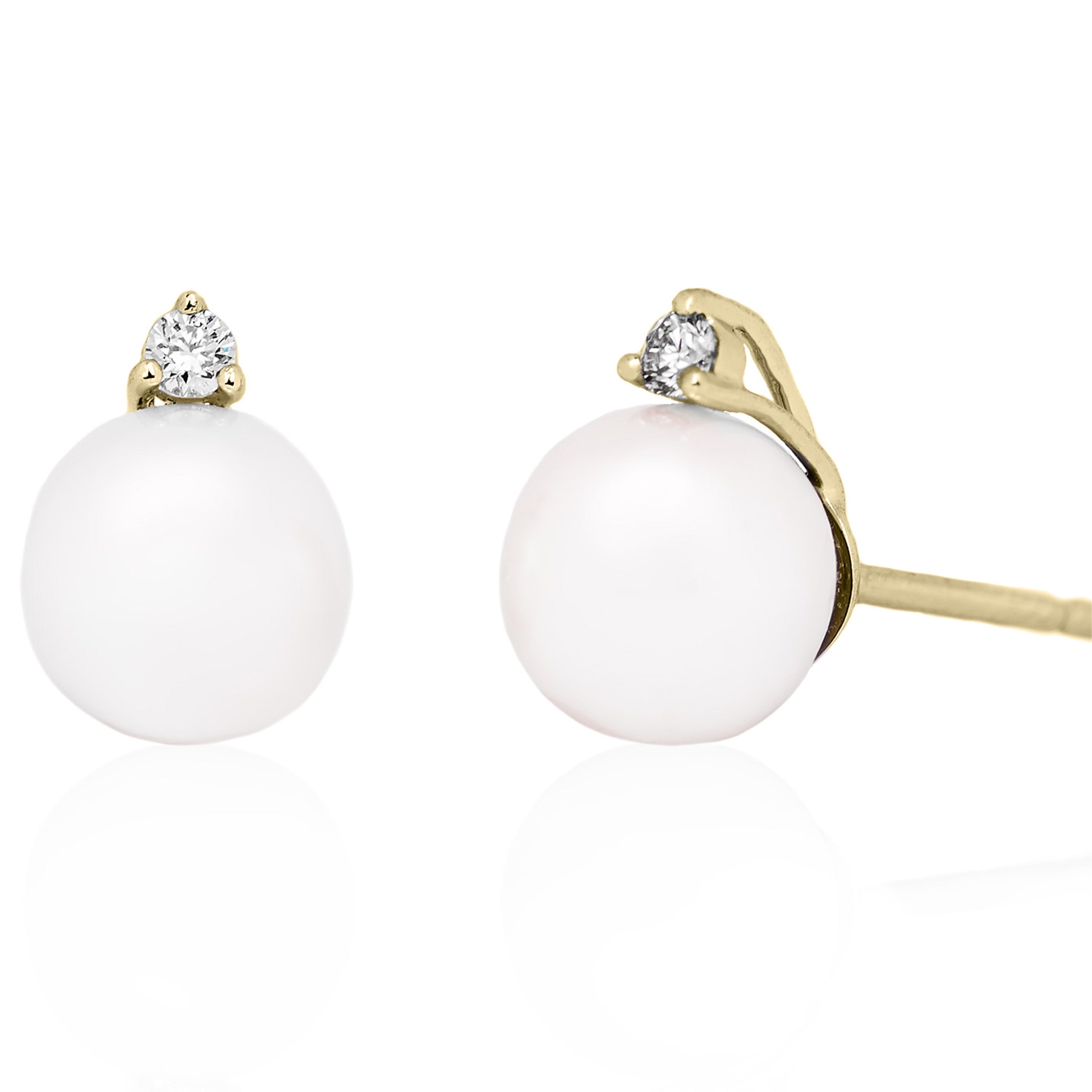 Pair of earrings with white spherical stones and gold accents on a white background