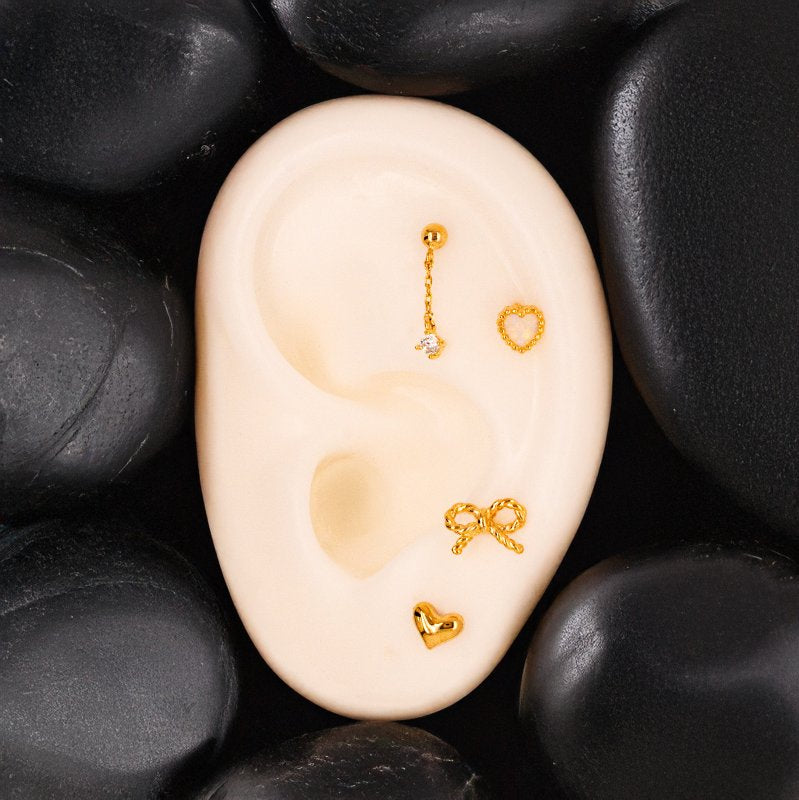 Gold stud earrings stacked on an earring display.