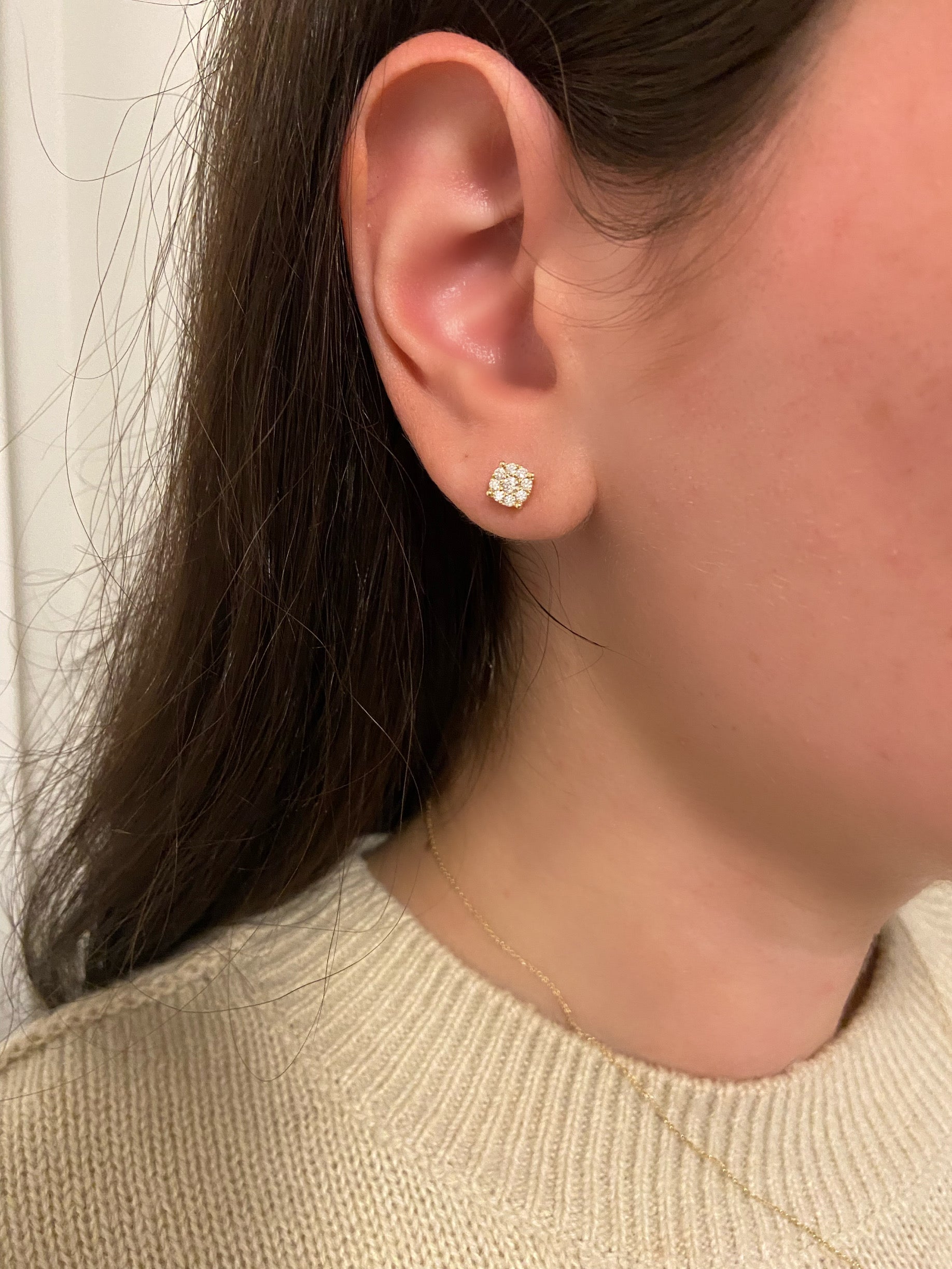 close up of ear wearing 14k yellow gold diamond cluster studs