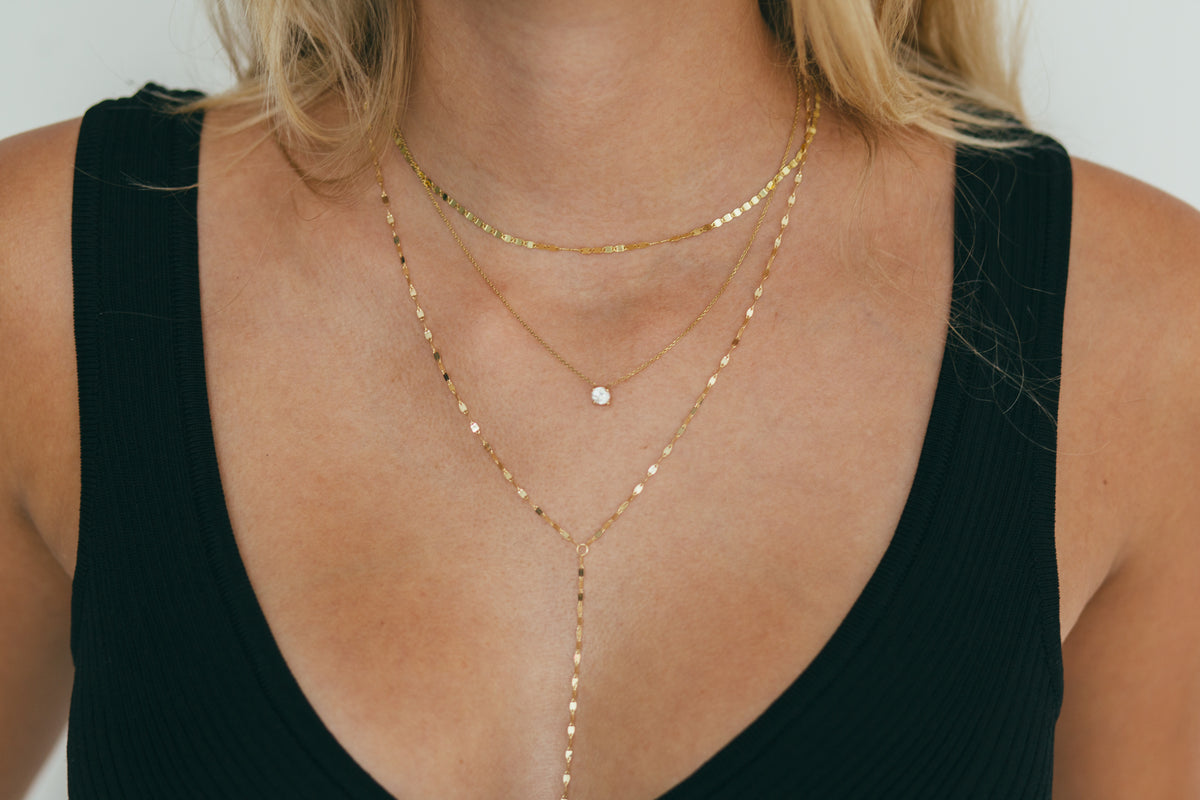 a stack of gold necklaces including a floating lab diamond necklace 