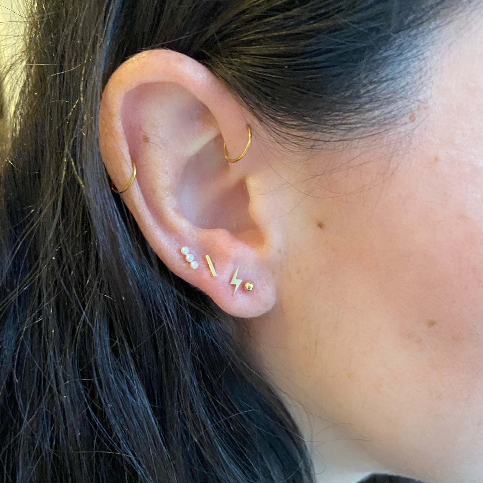 close up of ear wearing 4K Mini Gold Bar Stud with Flat Backing