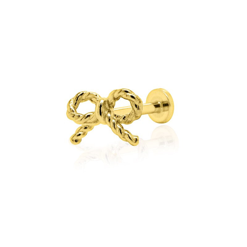 Gold bow-shaped earring on a white background
