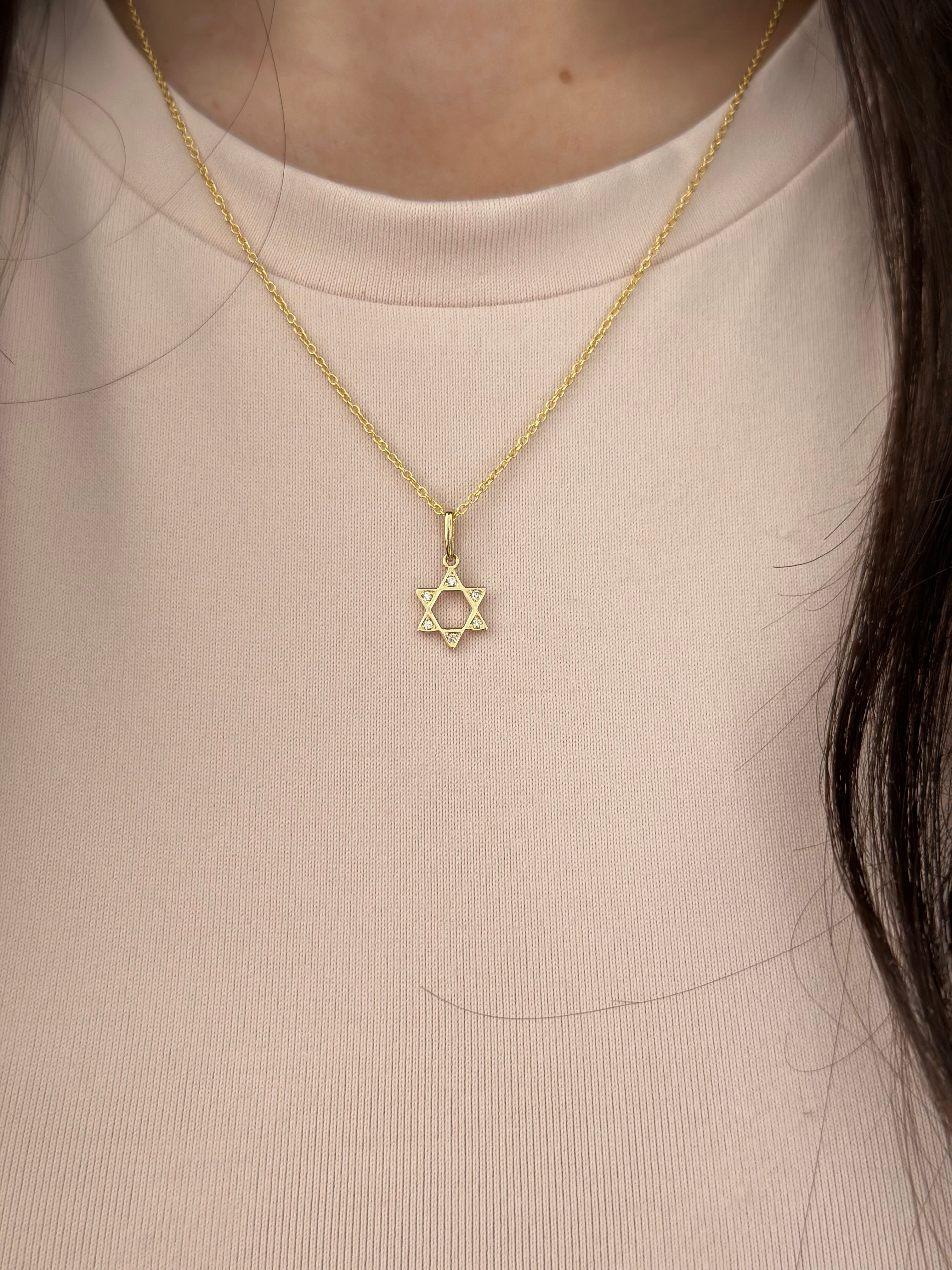 small open star of david pendant with diamonds in the corner an a pink background 