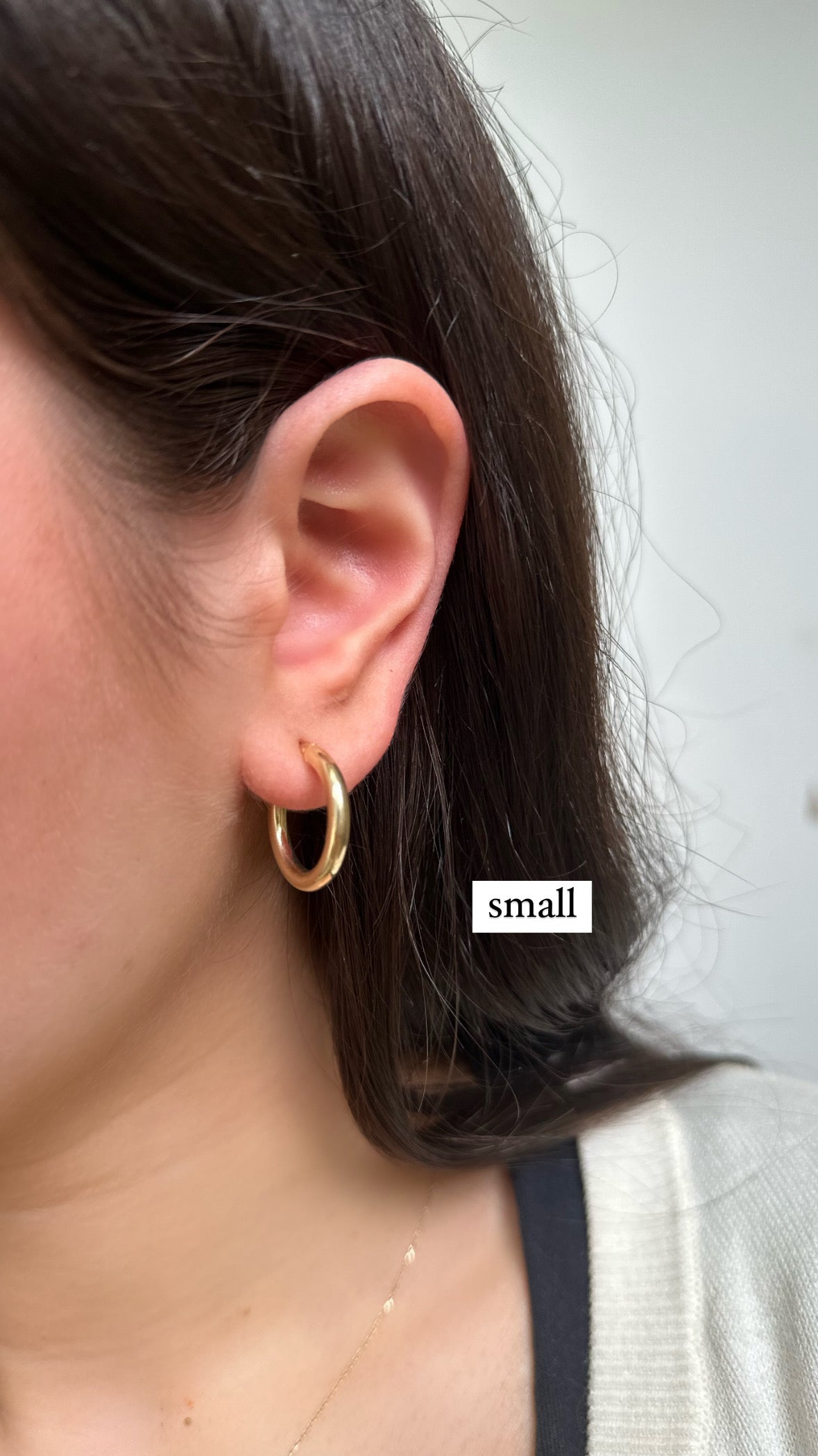 a girl wearing gold hoops in a small size