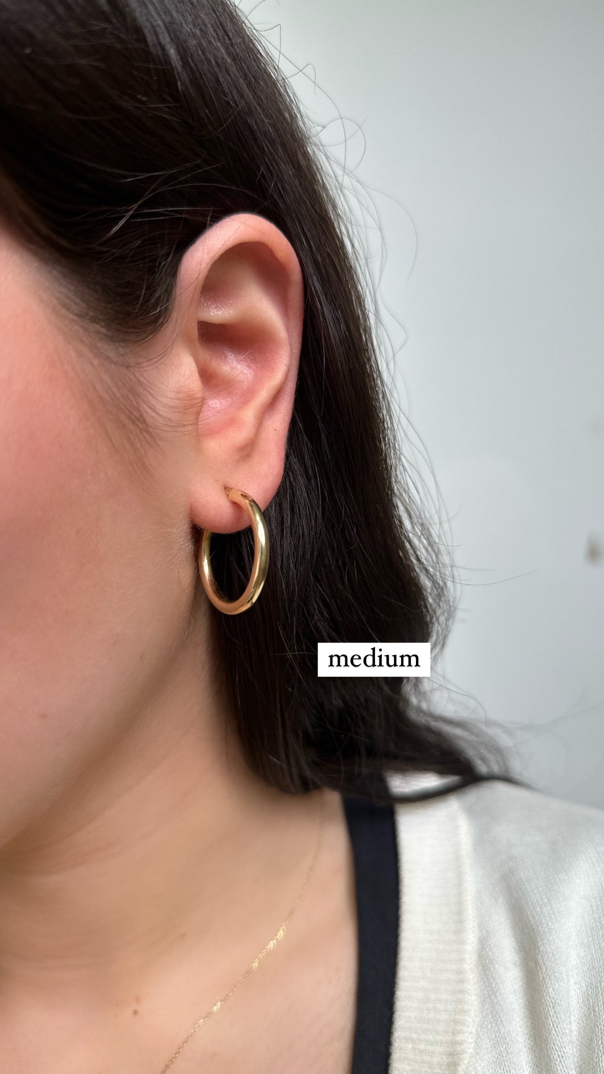 girl wearing gold hoops in a medium size