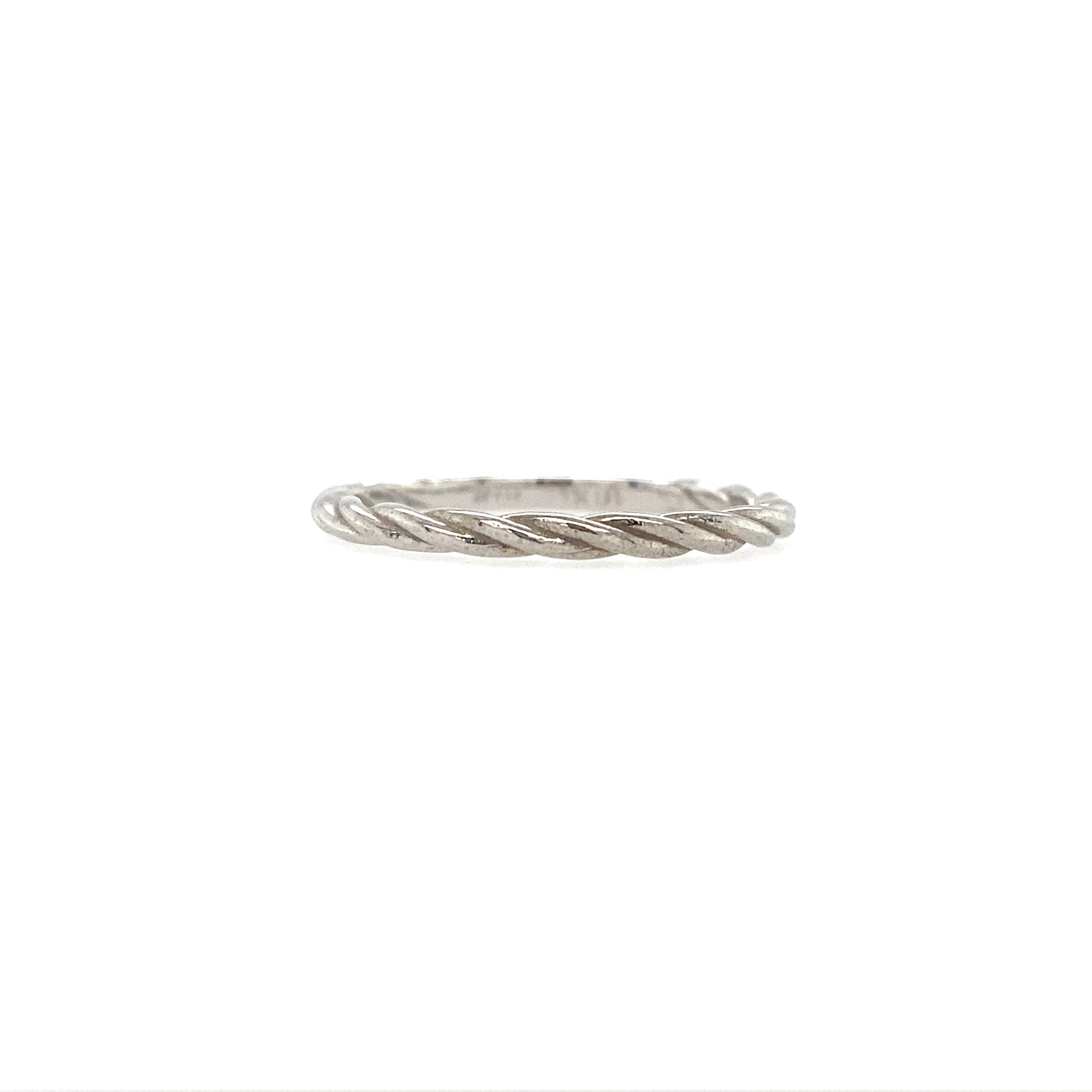 A white gold twisted rope ring agaisnt a white background.
