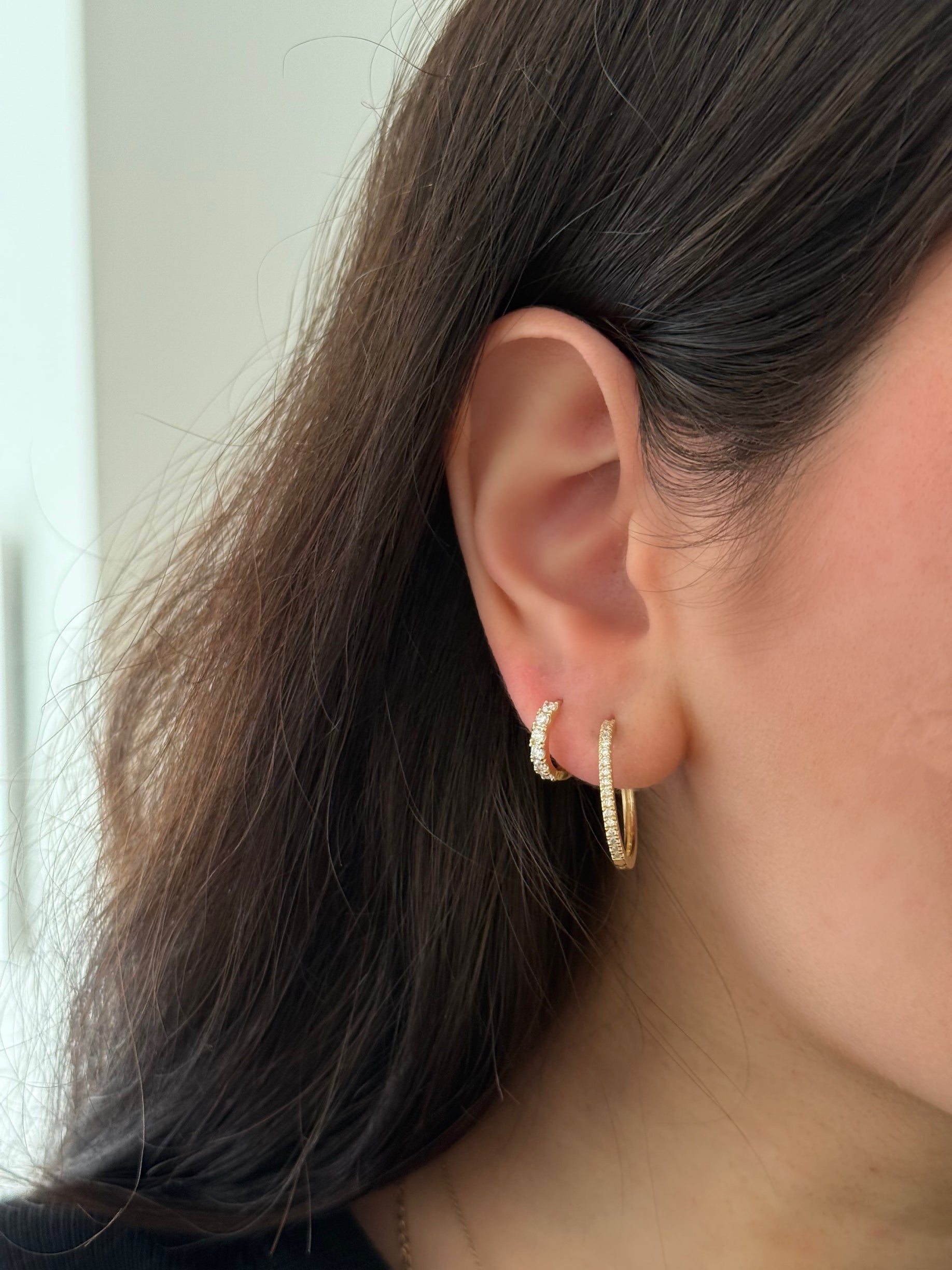 close up of ear wearing a stack of lab grown diamond earrings