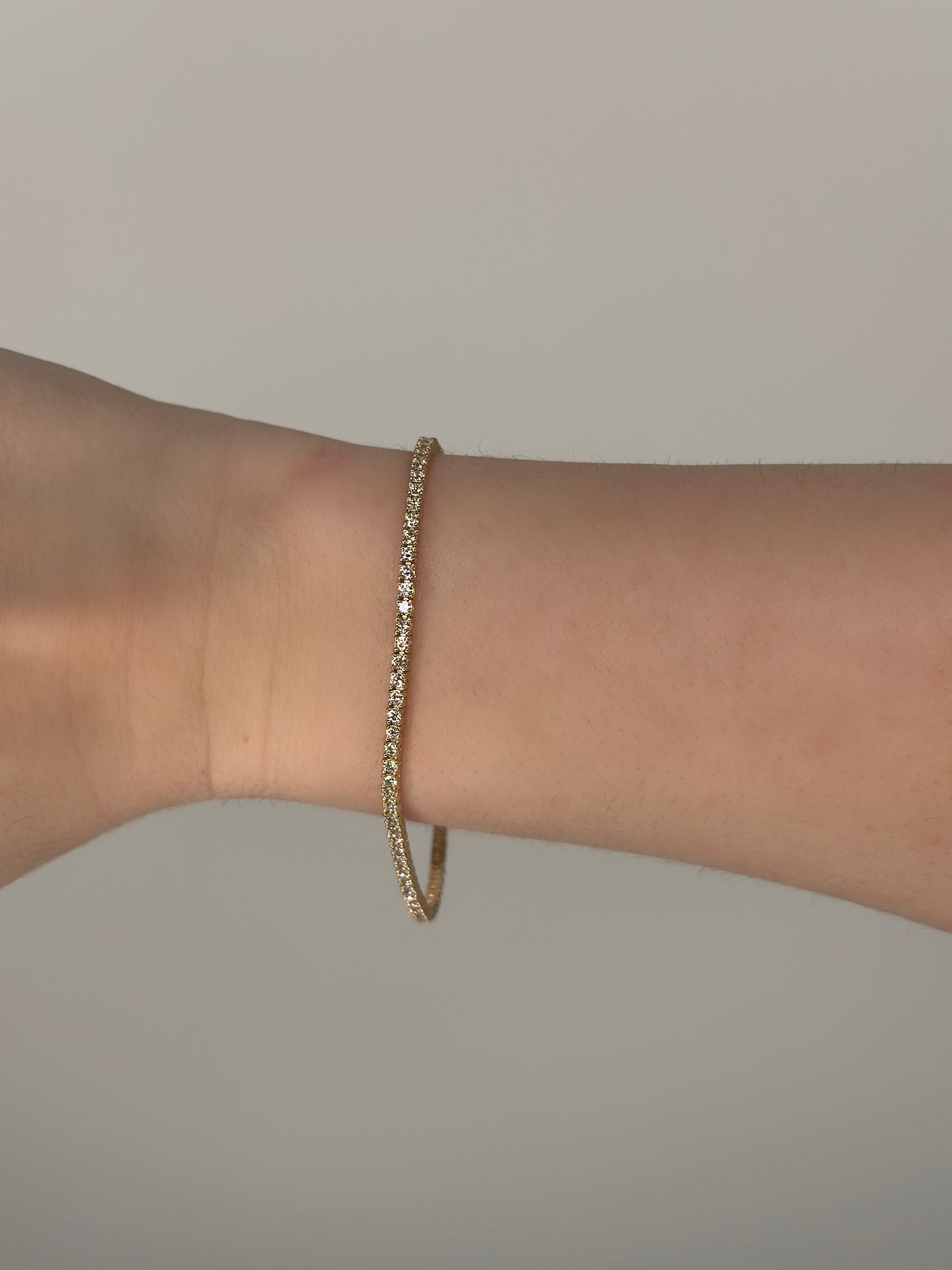 a close up of a yellow gold 2.6 carat lab tennis bracelet 