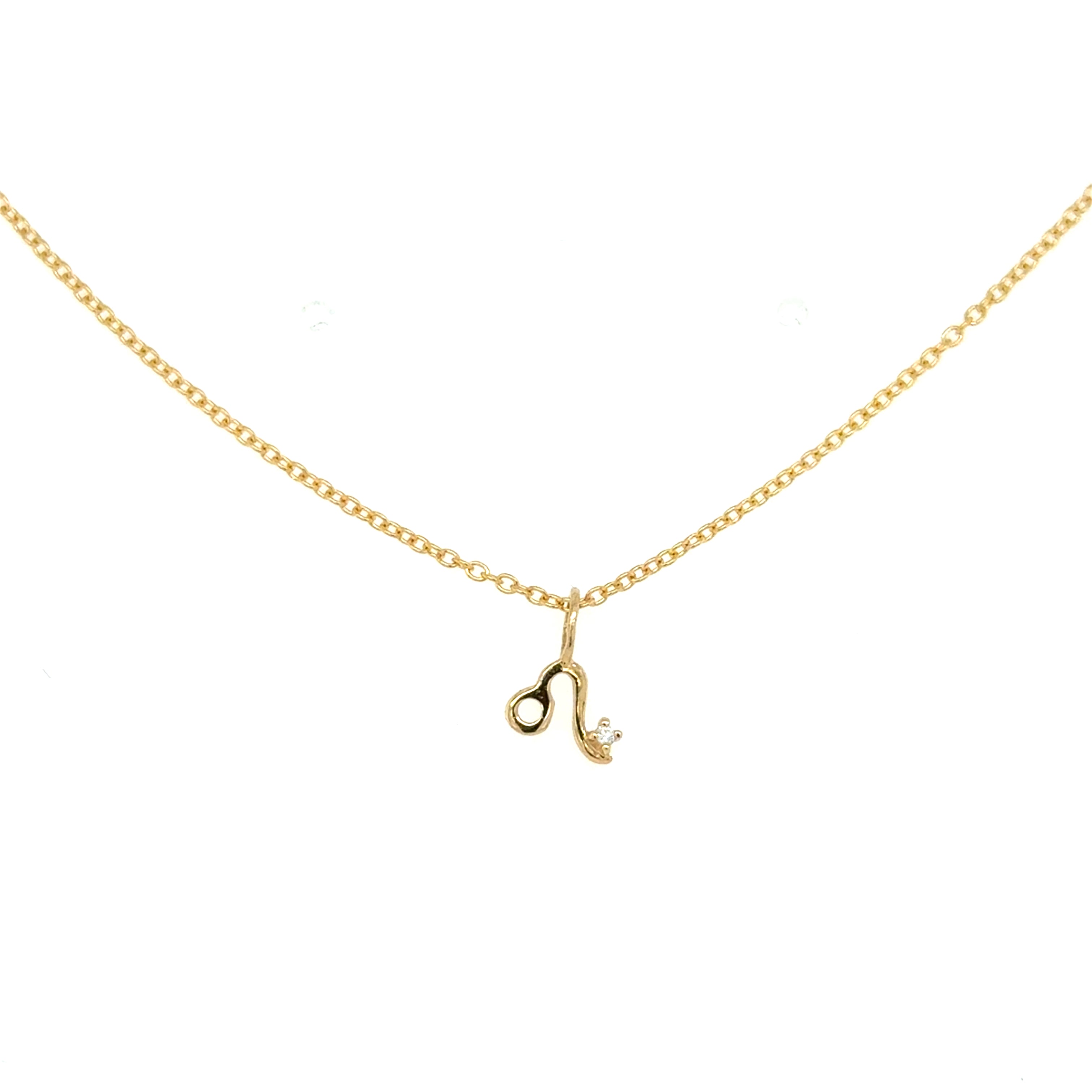 A small yellow gold charm in the shape of the Leo zodiac sign, suspended on a gold chain against a white background.